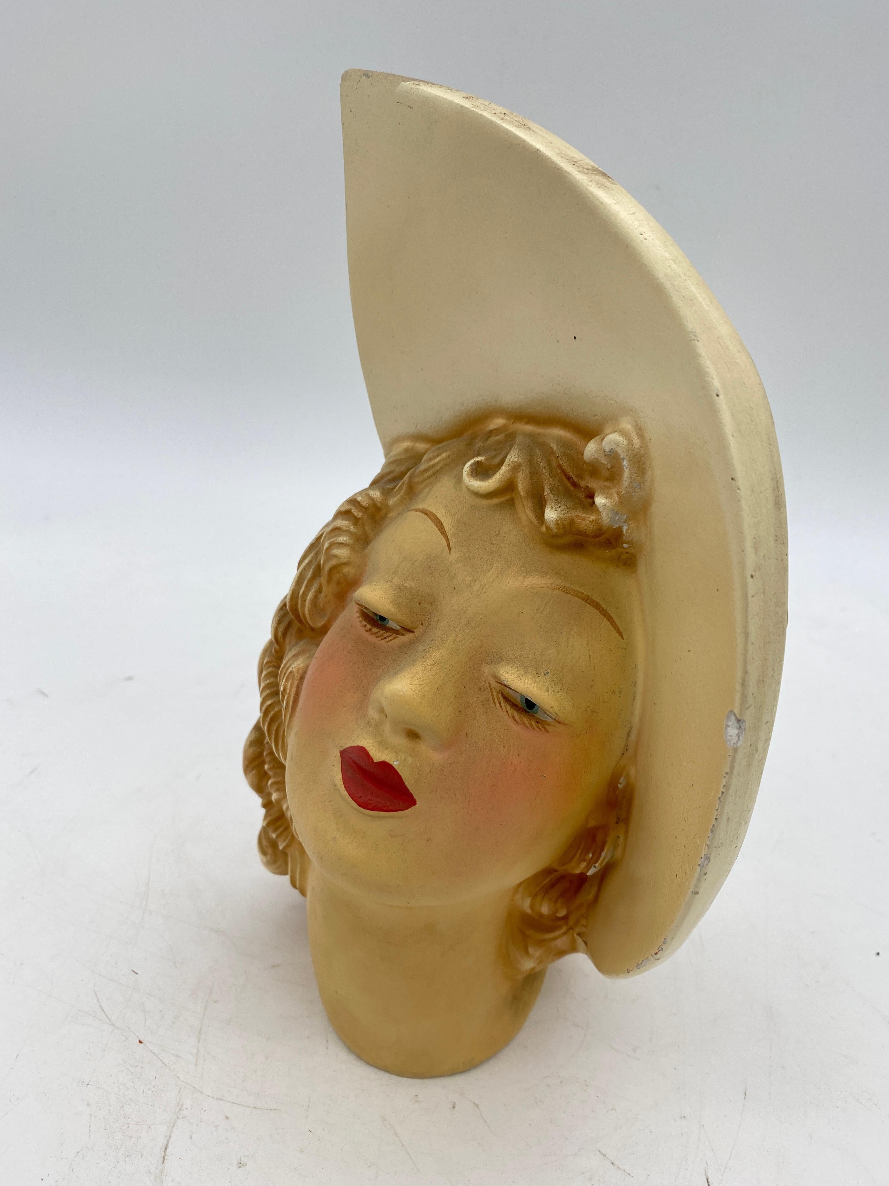 Post-War Resin Planter Beauty Female Bust featuring a beautiful bust of a young woman in a Sunday hat. the planter comes with a glass insert for the plant to ensure easy cleaning.