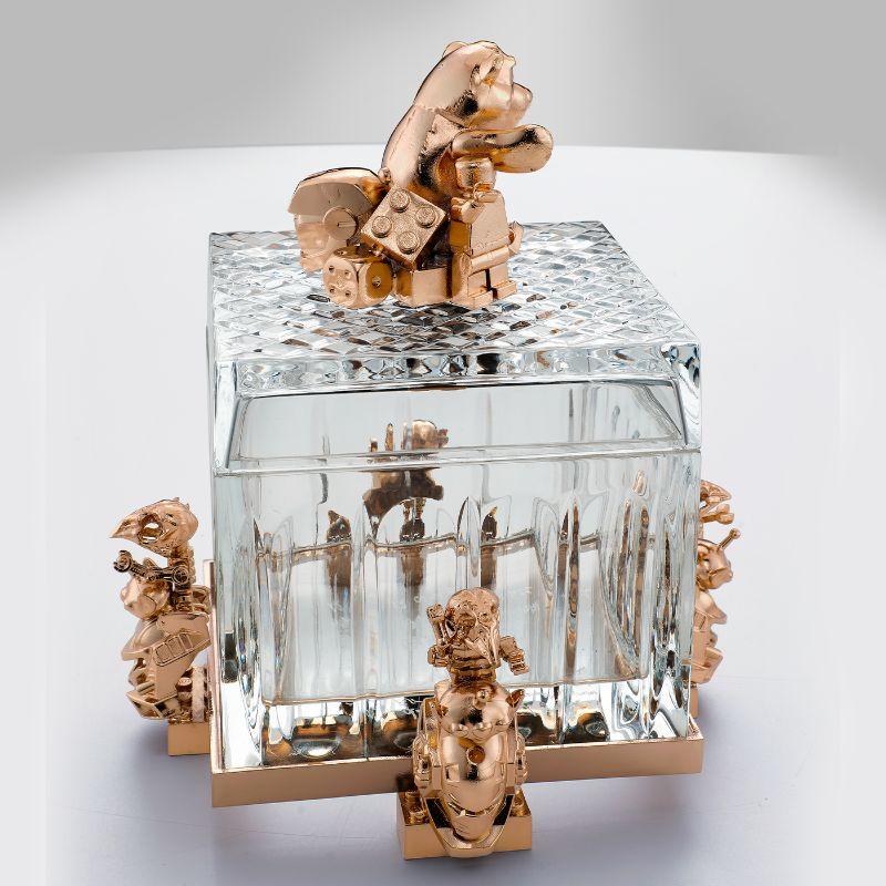 This extraordinary Pop Culture design by Leo Decarlo exclusively handcrafted for Vetralia will be a sublime addition to a refined contemporary interior. An engraved crystal box with a lid, it is decorated with gold-coated brass statuettes of Lego,