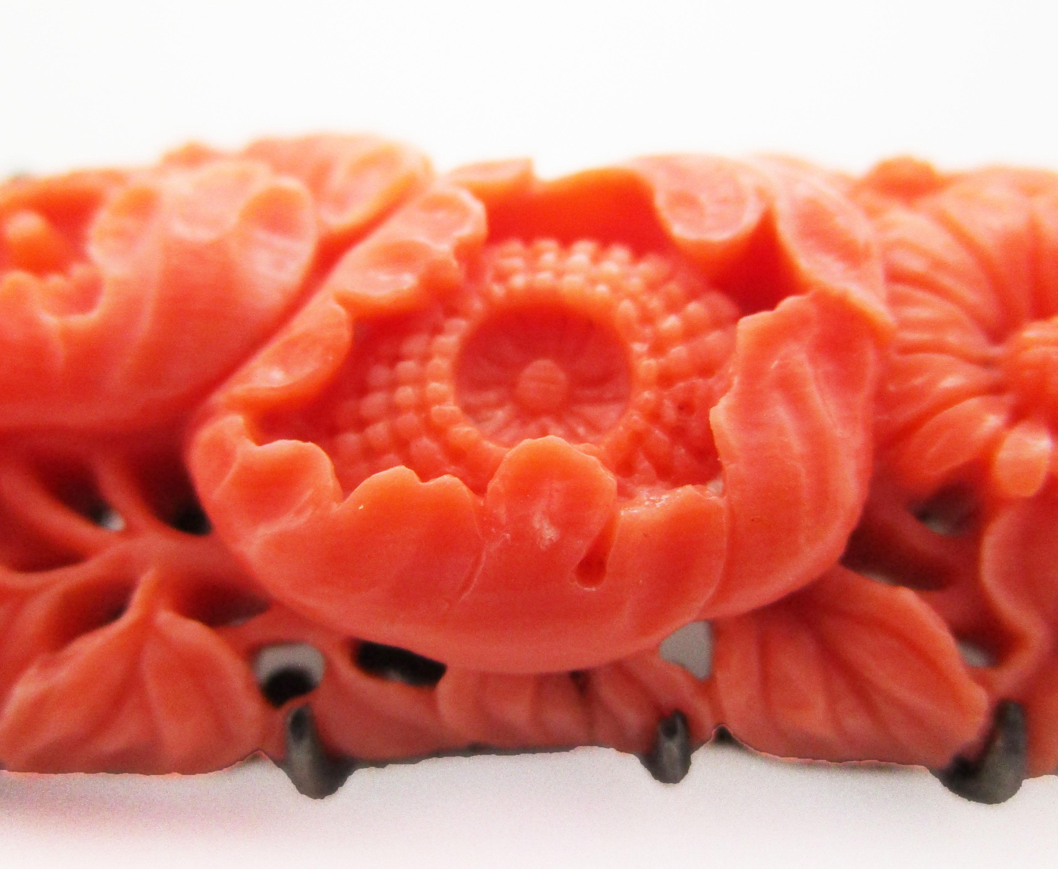 This gorgeous brooch is from the 1950s and has a stunning post World War II pedigree in hand-carved orangey-red natural undyed coral and sterling silver. The delicate hand carving features an incredible floral image of daisies overlaid by