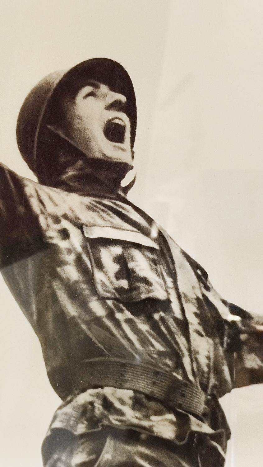Black-and-white poster from the 1970s of opposition to the Vietnam conflict depicting a soldier shot in the back with a large 