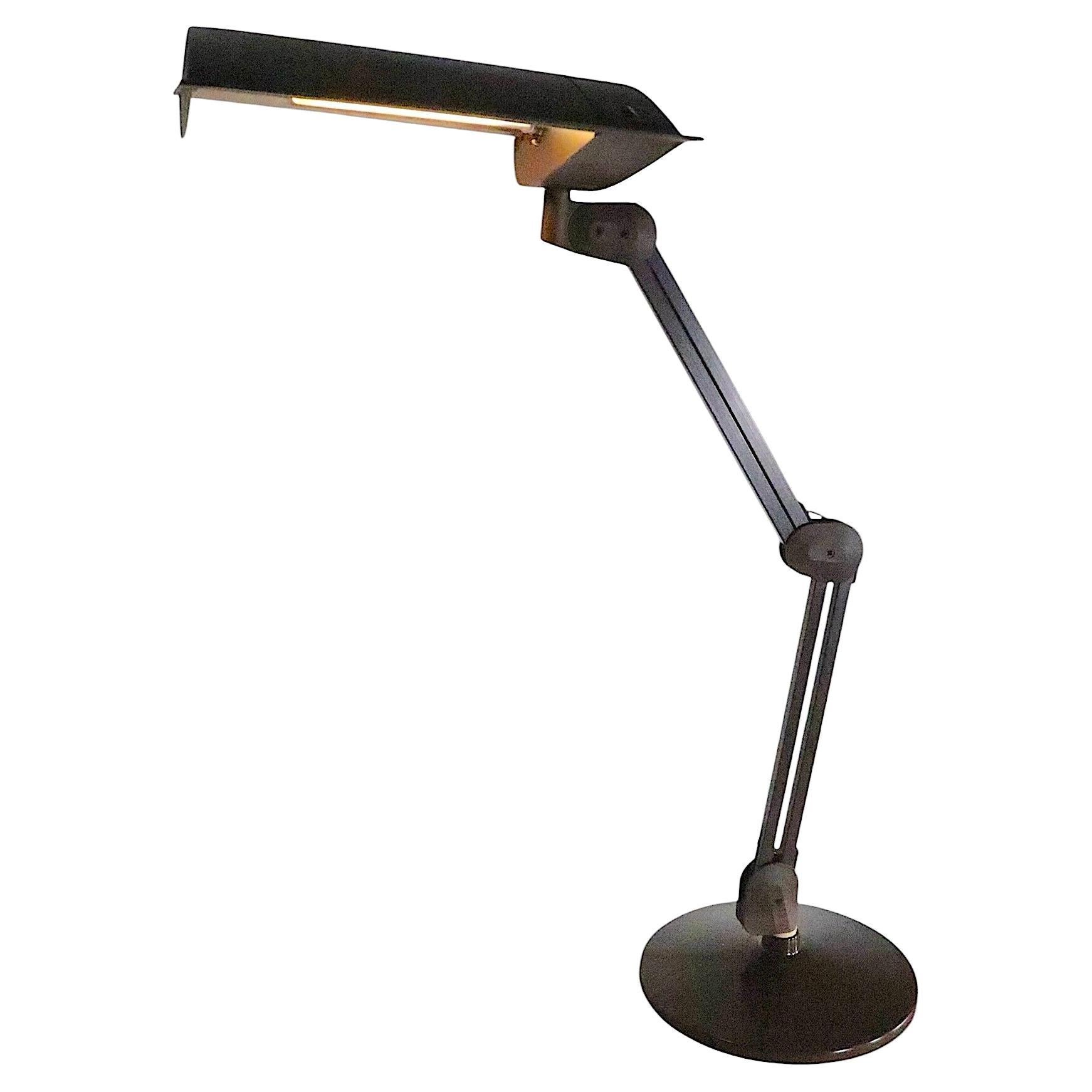 Ungewöhnliche verstellbare Schreibtischlampe von Luxo aus Dänemark. Dieses Modell verfügt über einen Kapuzenschirm und zwei Arme, die in der Mitte beweglich sind. Die Leuchte ist außerdem auf dem runden Sockel drehbar. Dieses Exemplar ist für eine
