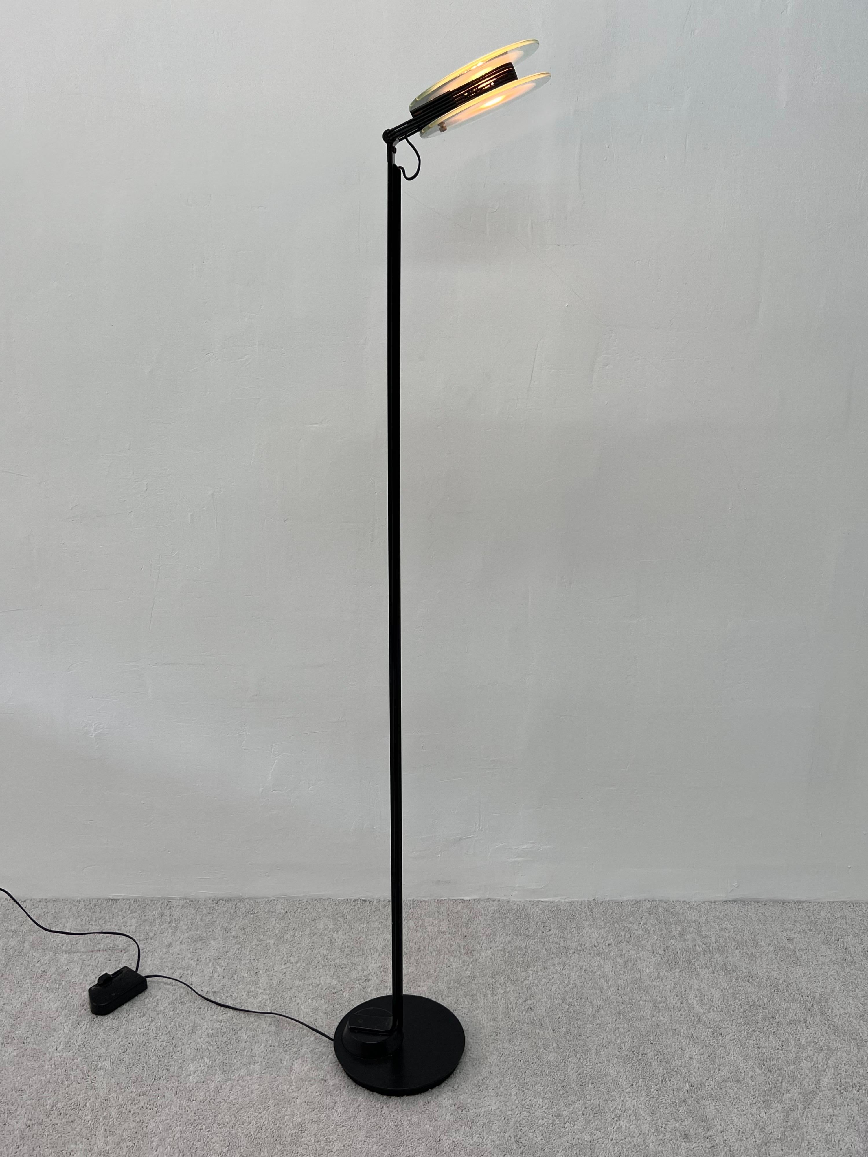 Postmodern Belux black enameled steel frame floor lamp with adjustable head halogen lamp and two glass pane diffusers.  Made in Spain.