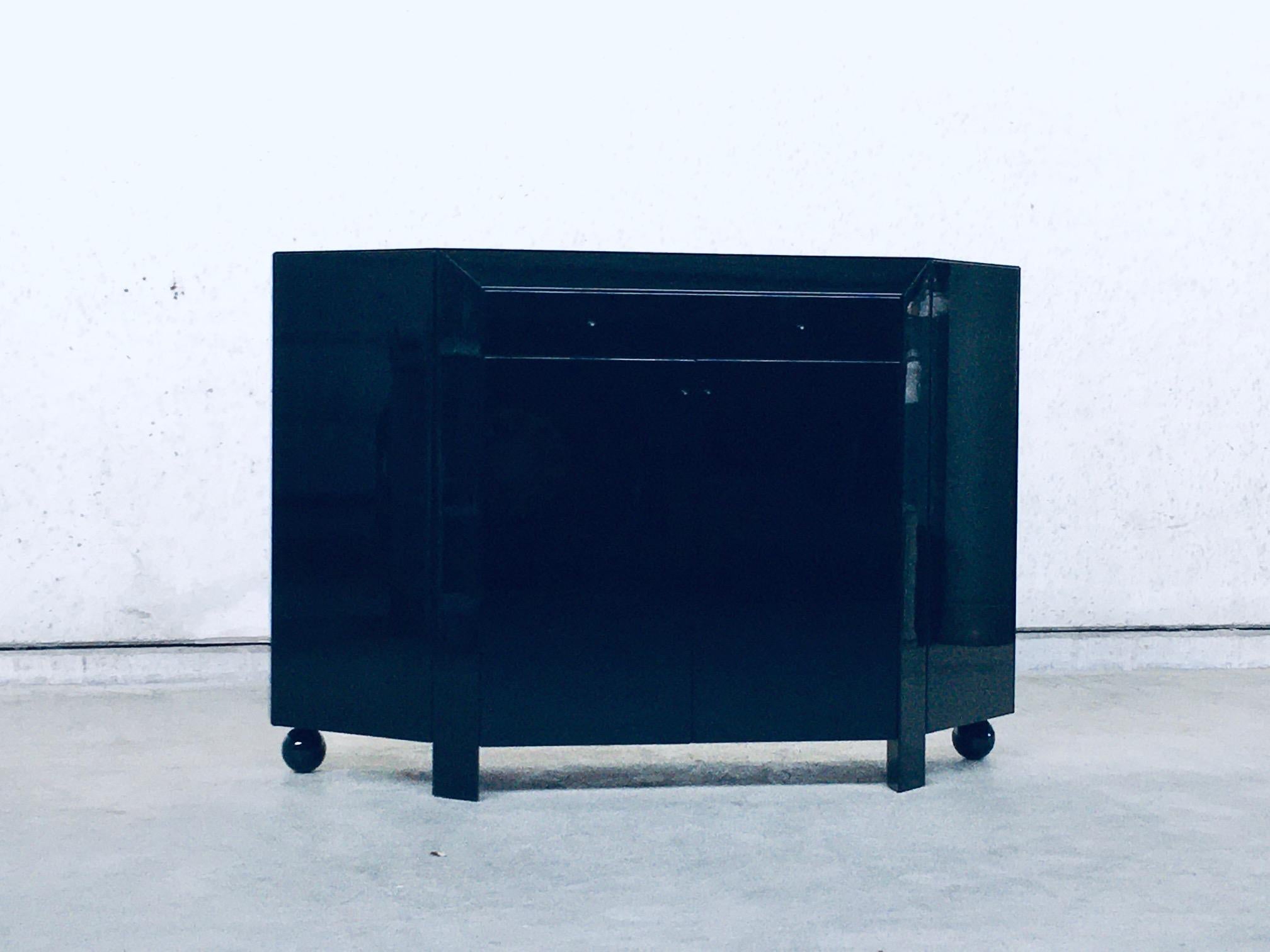 Postmodern Modern Architectural Design Bar Chest Cabinet by Interlübke, Germany 1980's. Black high gloss laquered wood cabinet bar chest. High quality finish. On each corner a side door with press release mechanism, a drawer and 2 panel doors in the