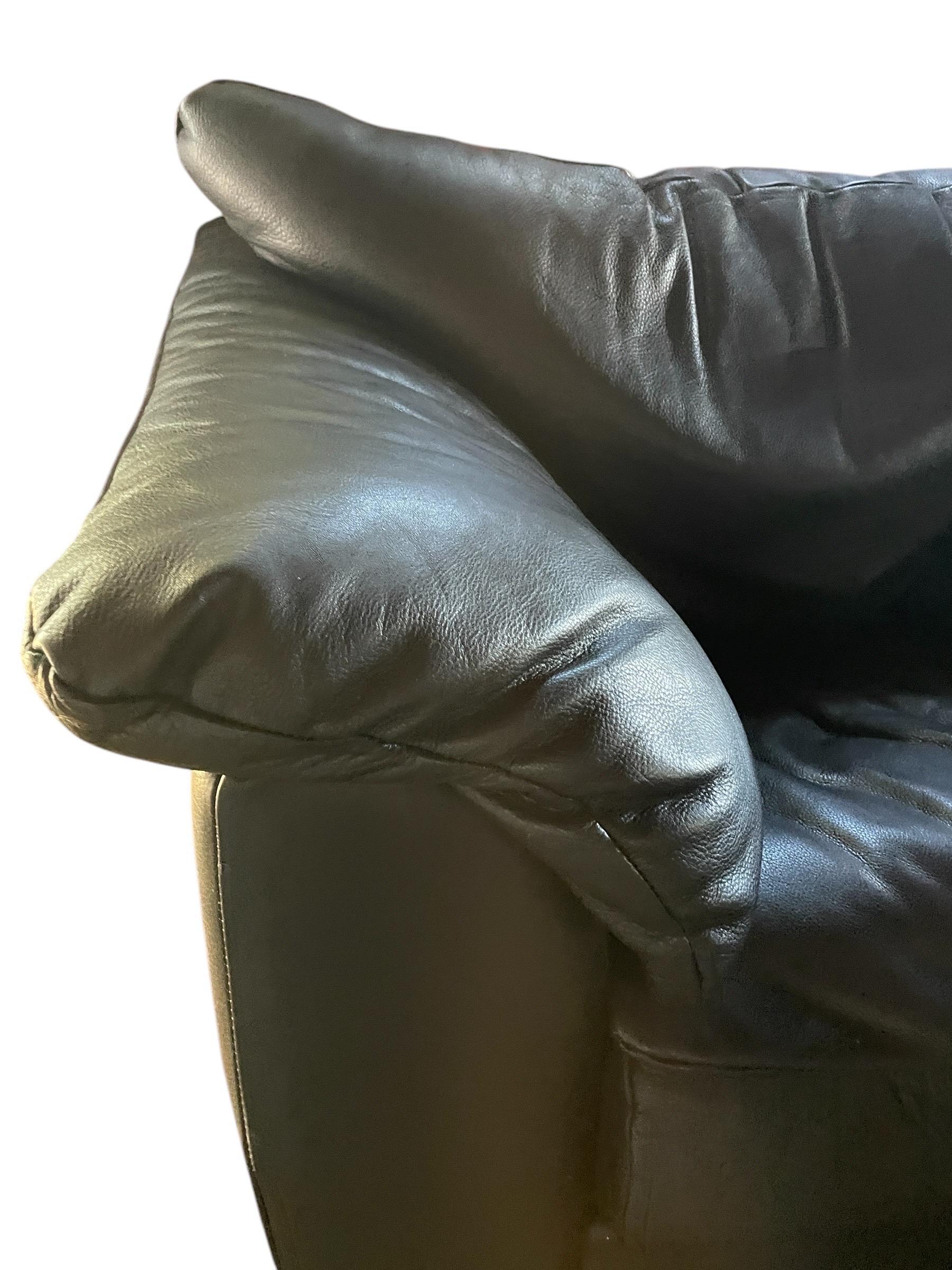 Black leather postmodern armchair. Top tier quality, incredibly comfortable top grain leather. The generous arm rests and back have a “sink into me” level of comfort. All leather is original and in gorgeous vintage condition. Back pillow zippers
