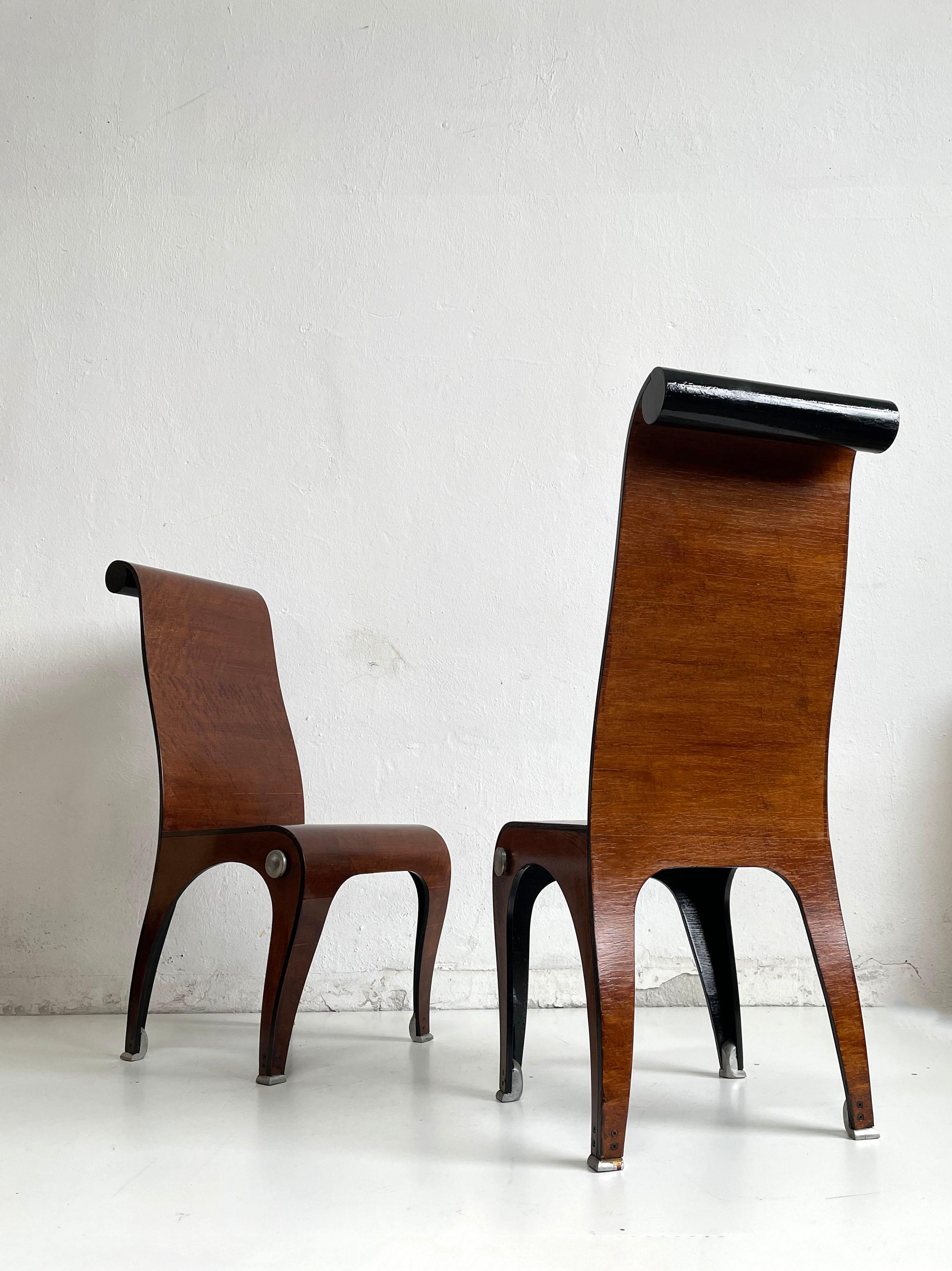 Very unusual pair of moulded curved plywood chairs with cast aluminium details, veneered in burr walnut and finished with shellac. Some details are painted in black.

2 sets, each consisting of 2 chairs, are available for sale. The price is per
