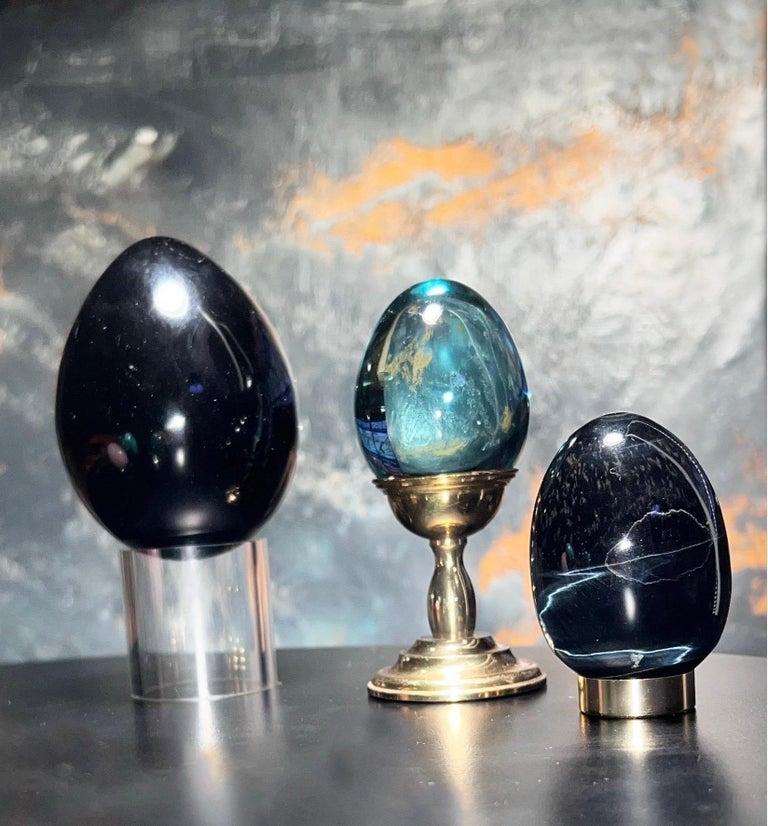 Carefully curated trio of glass and brass eggs with corresponding brass platform bases (2) for display. Set is comprised of 3 eggs and 3 bases.