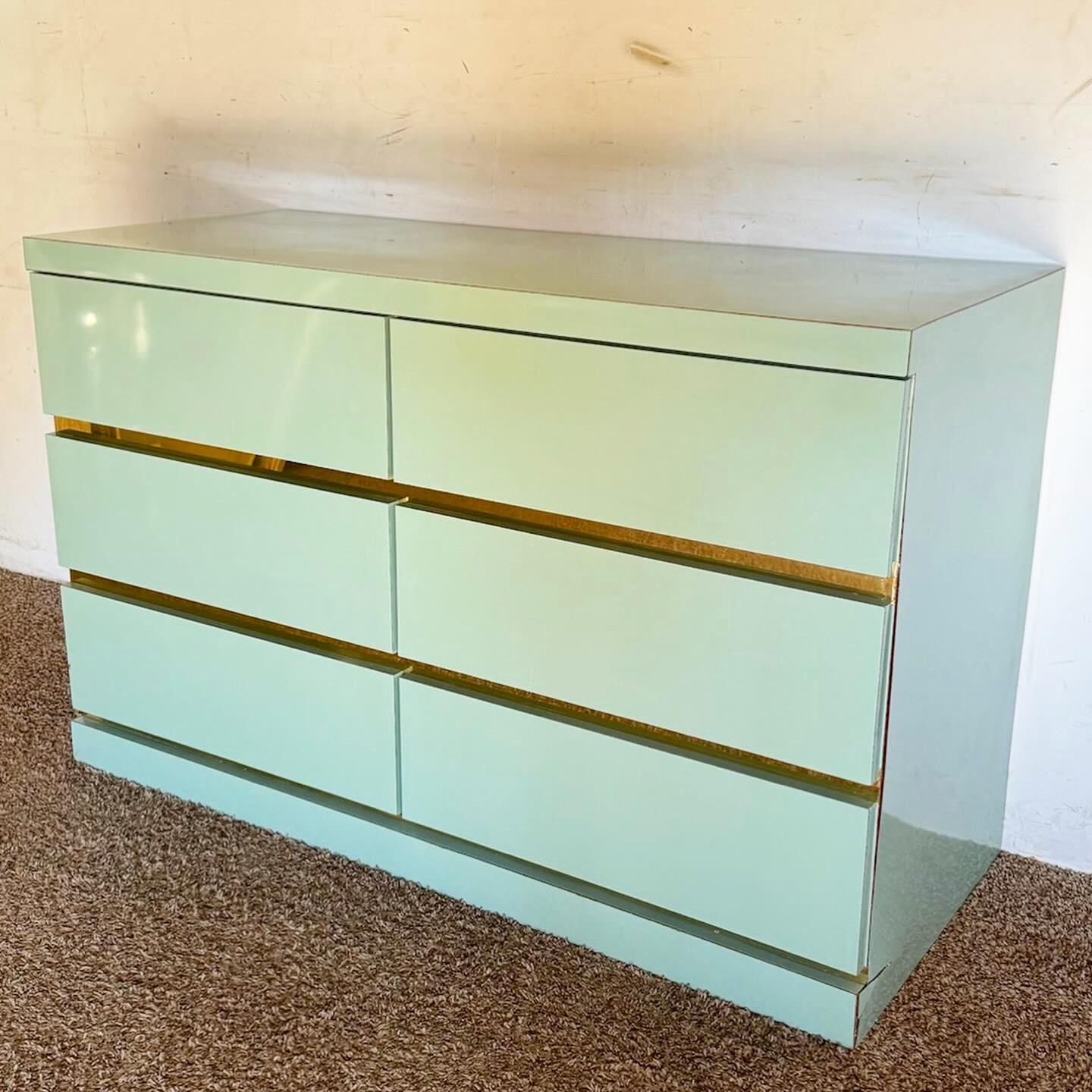Elevate your bedroom decor with the Postmodern Baby Blue Lacquer Laminate Dresser with Gold Accents. This dresser combines a vibrant baby blue finish with elegant gold highlights, offering ample storage and a perfect mix of modern style and