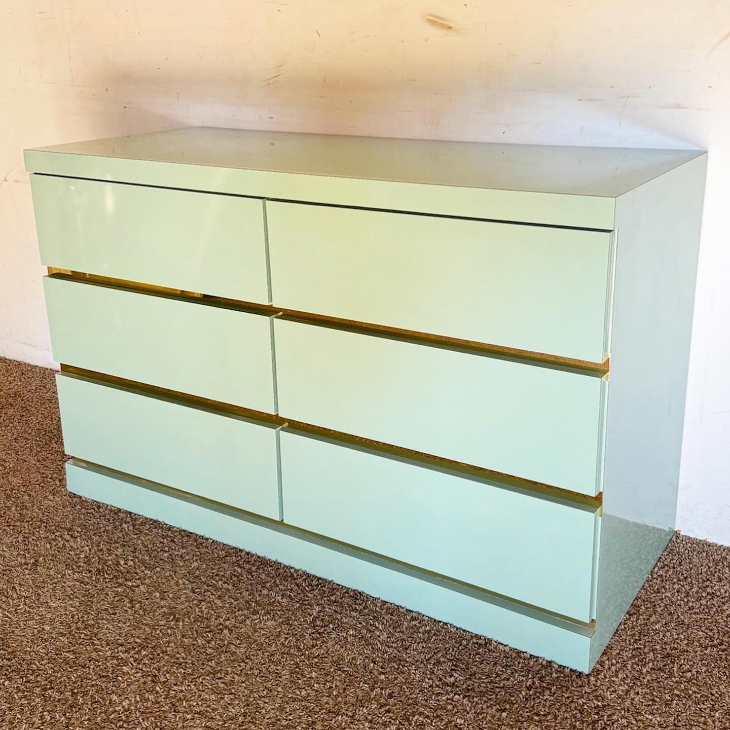 Transform your bedroom with the Postmodern Baby Blue Lacquer Laminate Dresser with Gold Accents. This dresser combines a fresh baby blue finish with luxurious gold details, offering ample storage and a perfect balance of contemporary elegance and