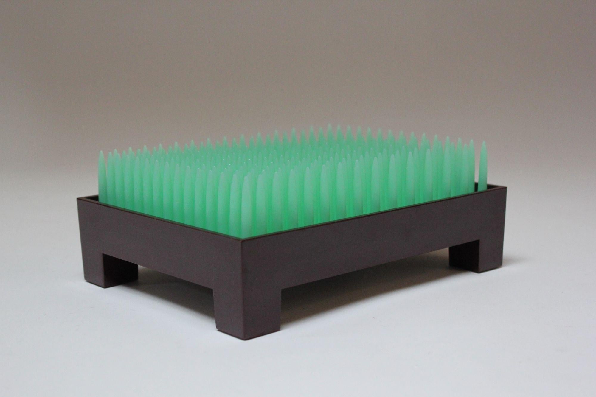 Der Liberte Briefhalter/Schreibtischaufsteller/Briefumschlagkasten wurde vom französischen Industriedesigner/Architekten Philippe Starck für Alessi (Portugal, 1992) entworfen.
Die grüne Kunststoffplatte, die von einem kastanienbraunen Bakelit-Sockel