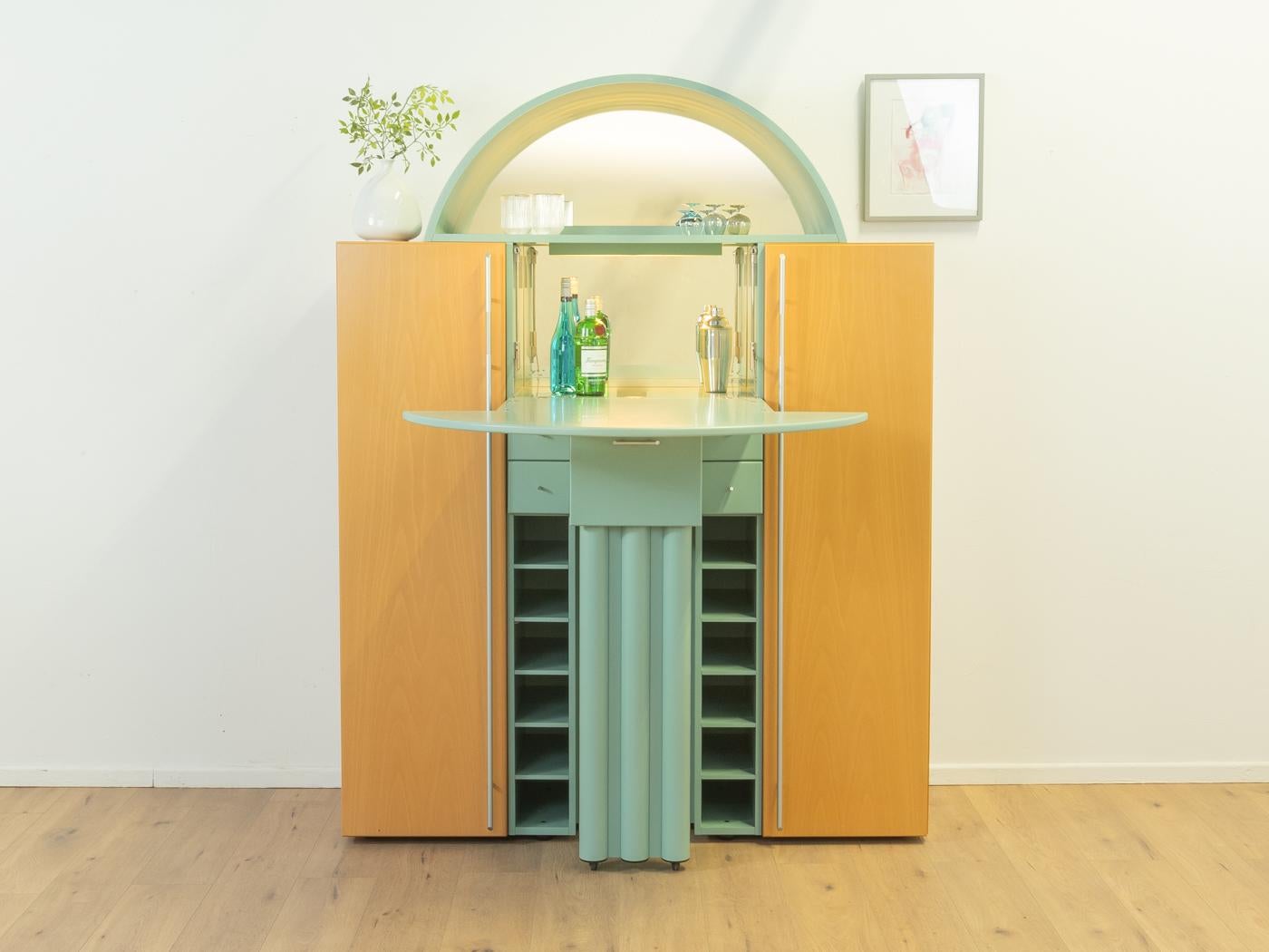 Postmodern three-part bar cabinet by Peter Maly for the DUO series by interlübke from the 1980s. Corpus consisting of two cabinets in ash veneer and a mint green lacquered bar element with two doors, a hinged door, two mirrors, five drawers, twelve