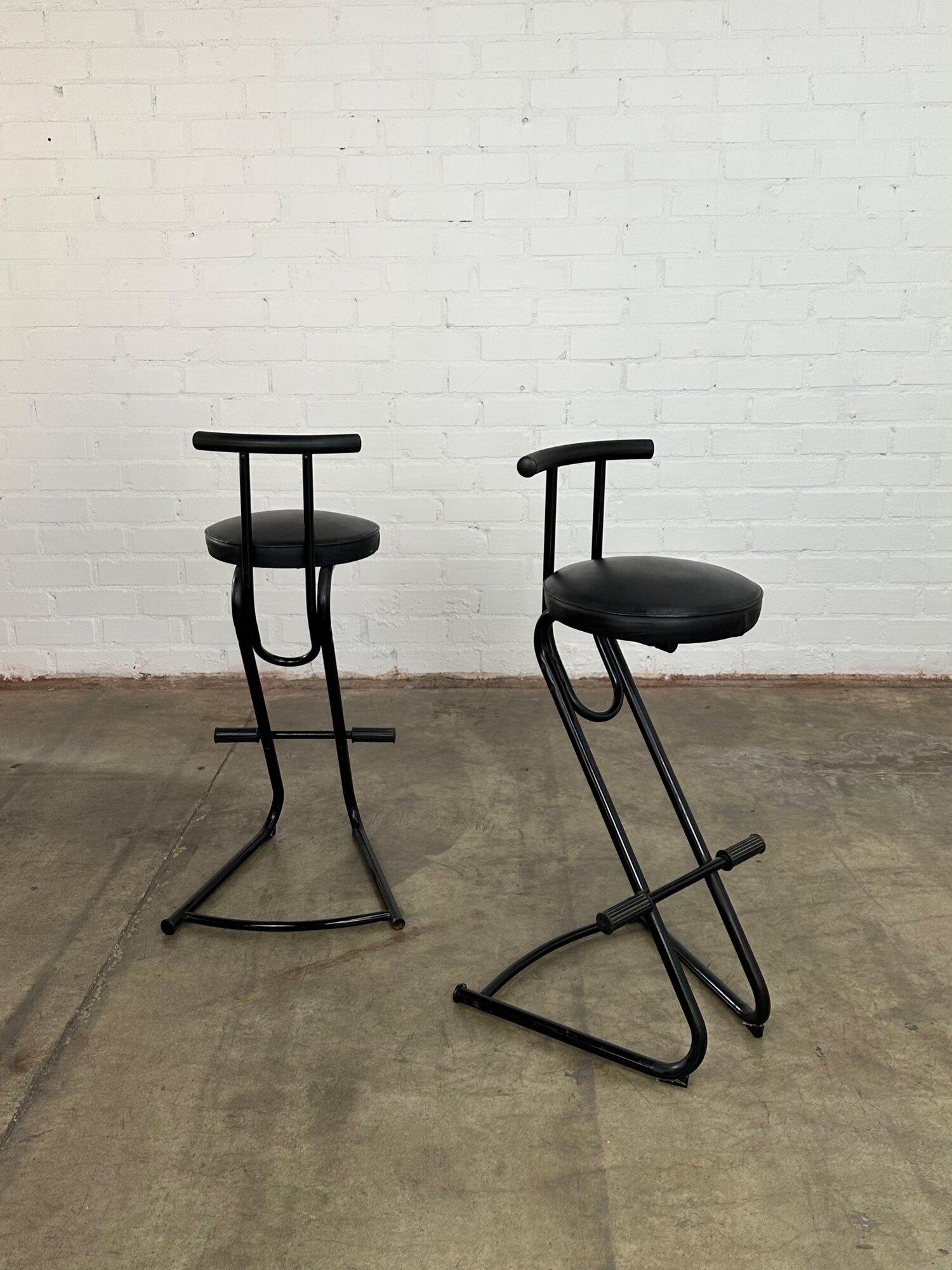 Measures: W20 D21 H39.5 SW14 SD14 SH31

Black postmodern barstools with vinyl seats. Item is in good vintage condition, no visible rips or tears. Price is for the pair.