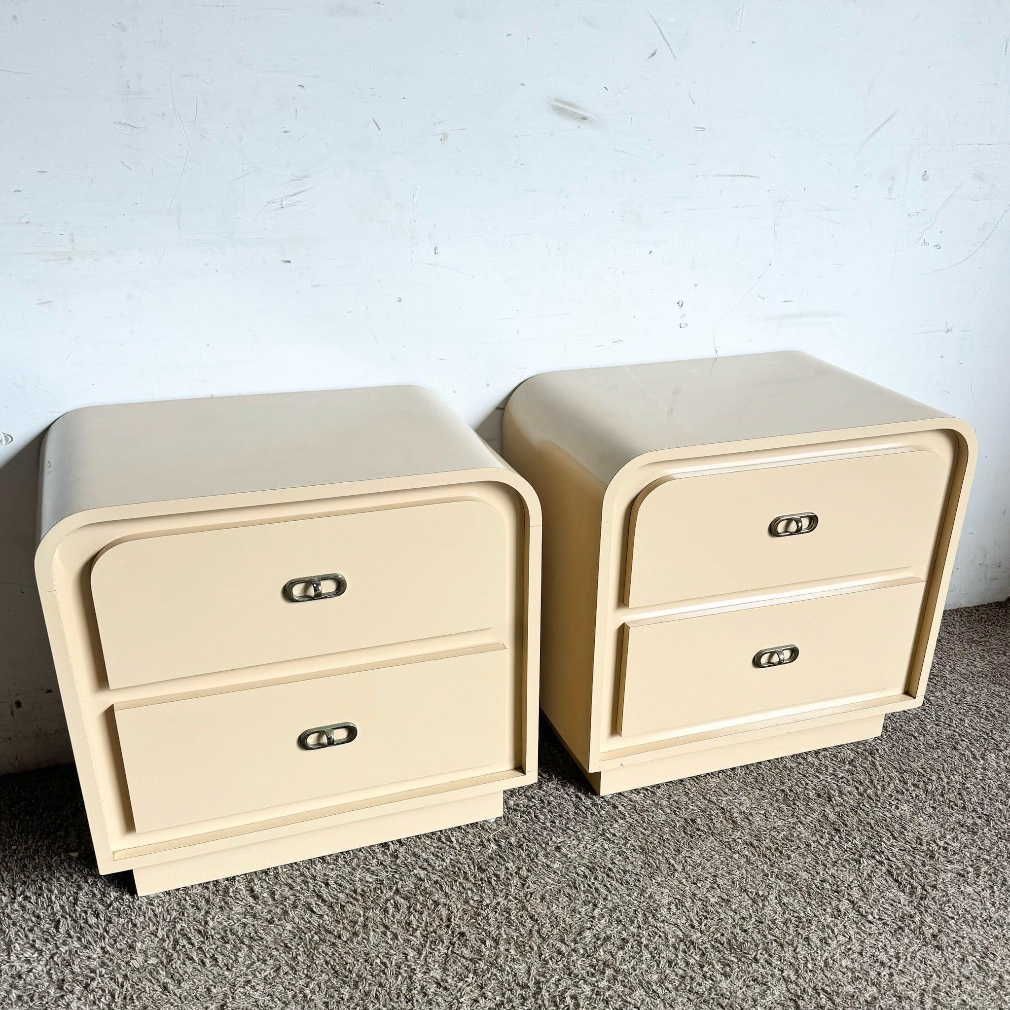 Postmodern Beige Lacquer Waterfall Nightstands with a minimalist design and two spacious drawers. Perfect for modern, sleek bedrooms.
 
 Some wear around the edges as shown in the photos.
 We sell items as acquired, without restoring or repairing.