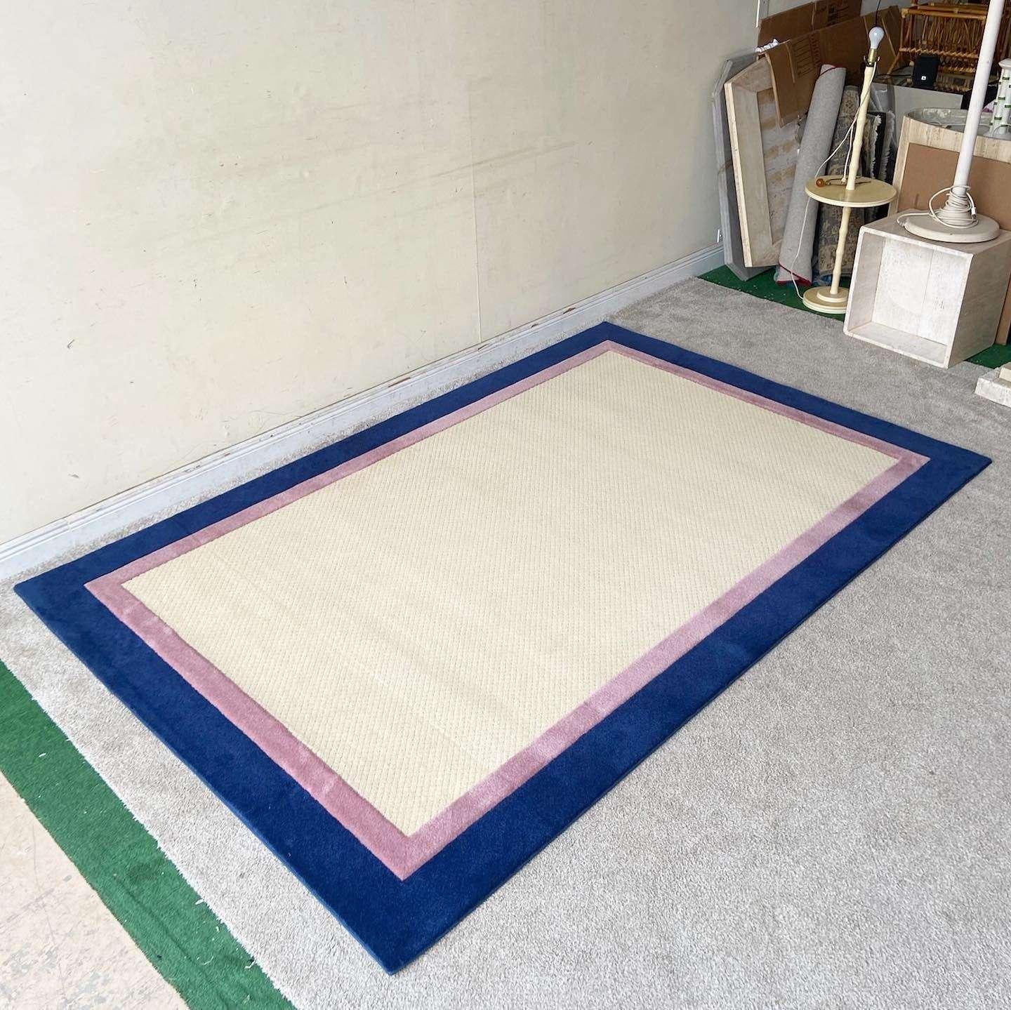 Exceptional vintage postmodern rectangular area rug. Features a beige interior with a pink border and dark blue outer edge.

Rug 20
