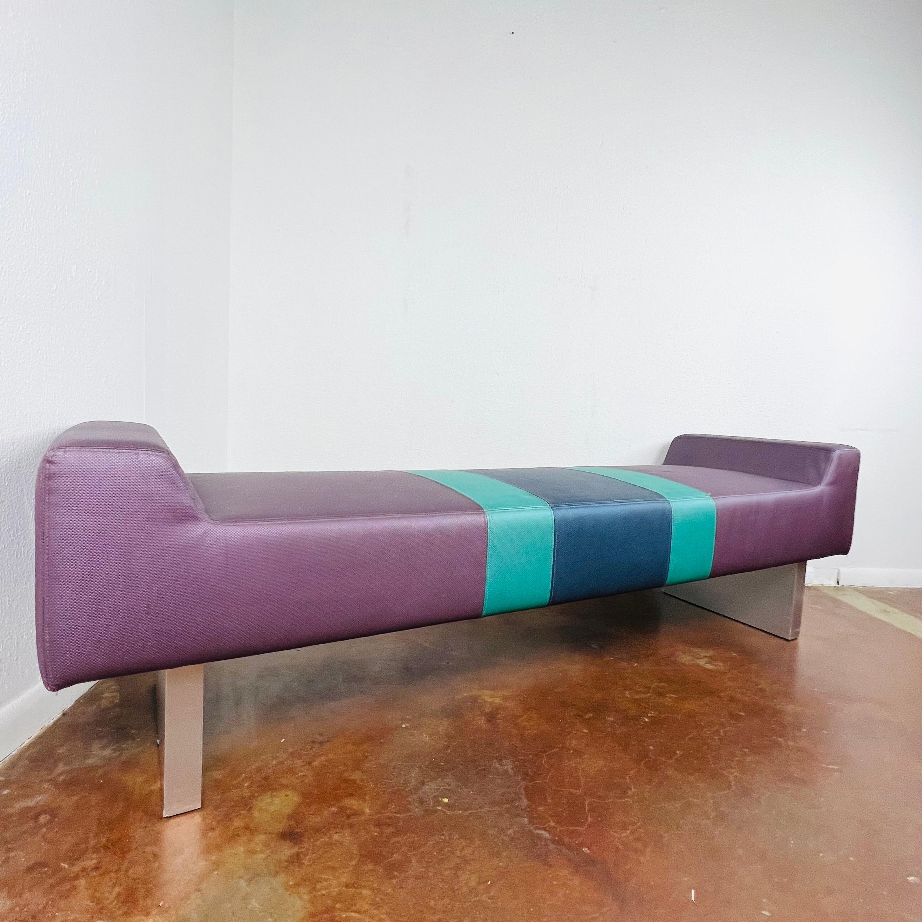 Unique postmodern bench in the style of the Memphis Group. Comprised of purple vinyl upholstered foam cushions with turquoise and blue center stripe and extruded brushed aluminum bases. Good condition with 2 small imperfections on vinyl seat, but