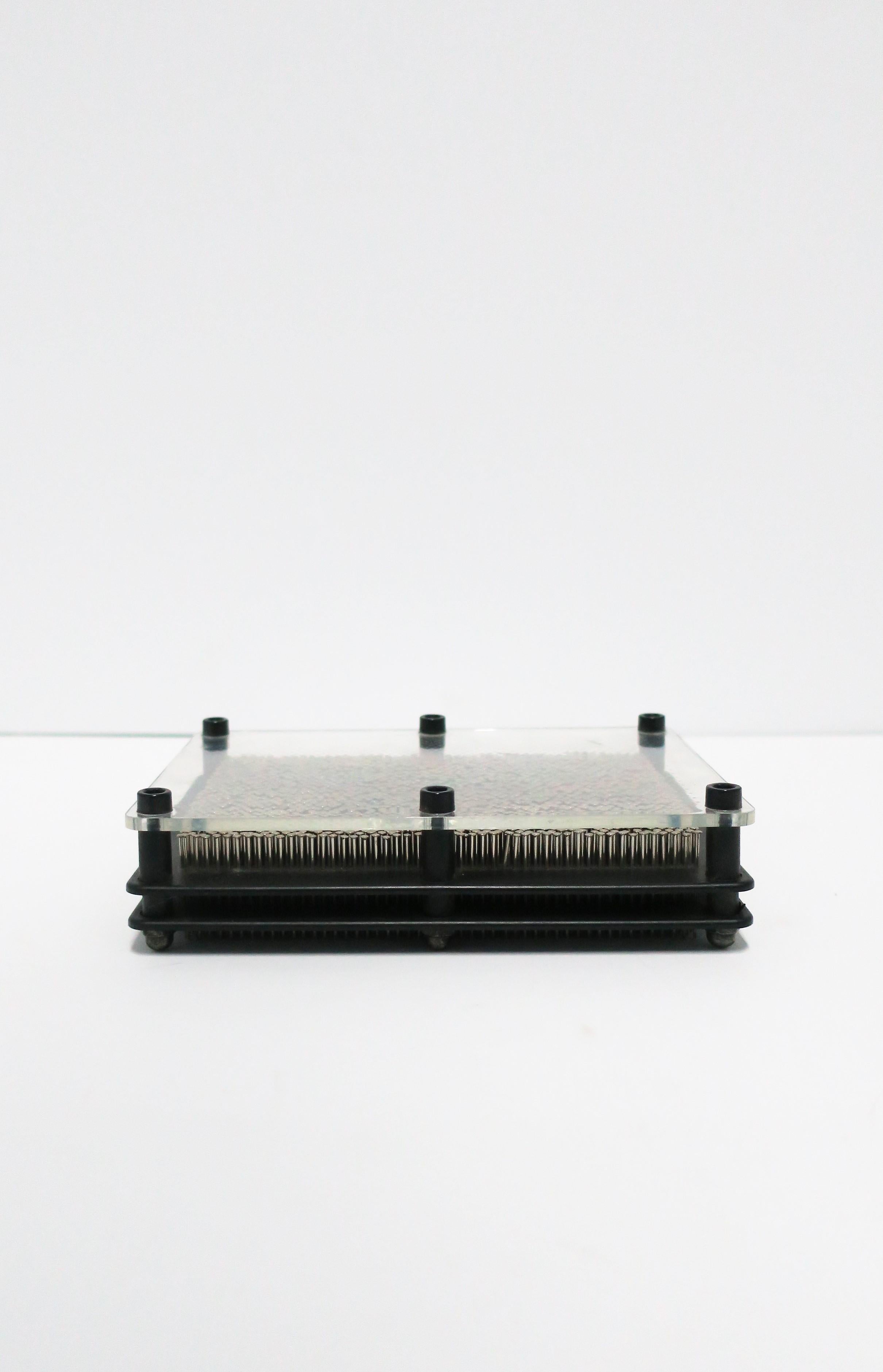 A Postmodern period black metal and clear acrylic with steel nails decorative object, circa late-20th century. Piece is rectangular in shape, comprised of three pieces acrylic (black and clear), black metal screws and thin metal nails (approximately