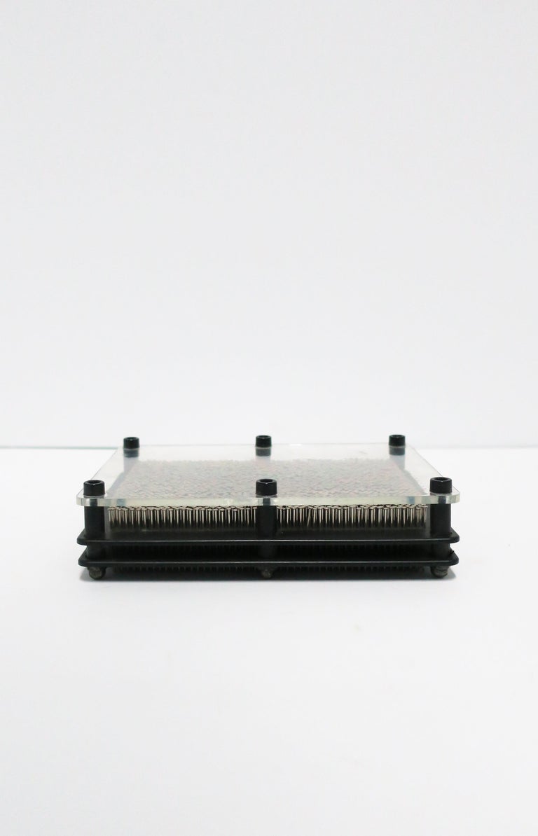 A Postmodern period clear and black acrylic and metal decorative object, circa late 20th century.
Piece is rectangular in shape, comprised of three pieces acrylic (black and clear), black metal screws and thin metal nails (approximately 1000),
