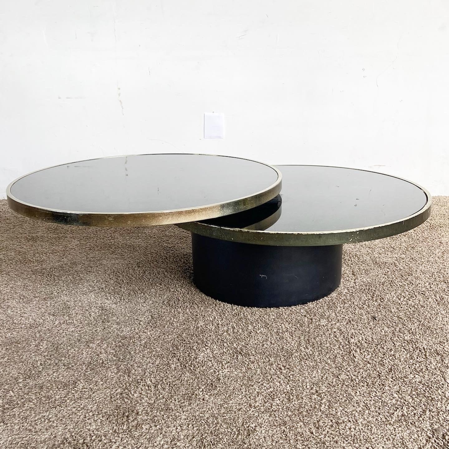 Elevate your space with our Postmodern Black and Gold Swivel Glass Top Coffee Table, offering an innovative design and dynamic display for any contemporary setting.

Two-tier design, each with a black inlaid glass top, adds a modern touch.
Upper