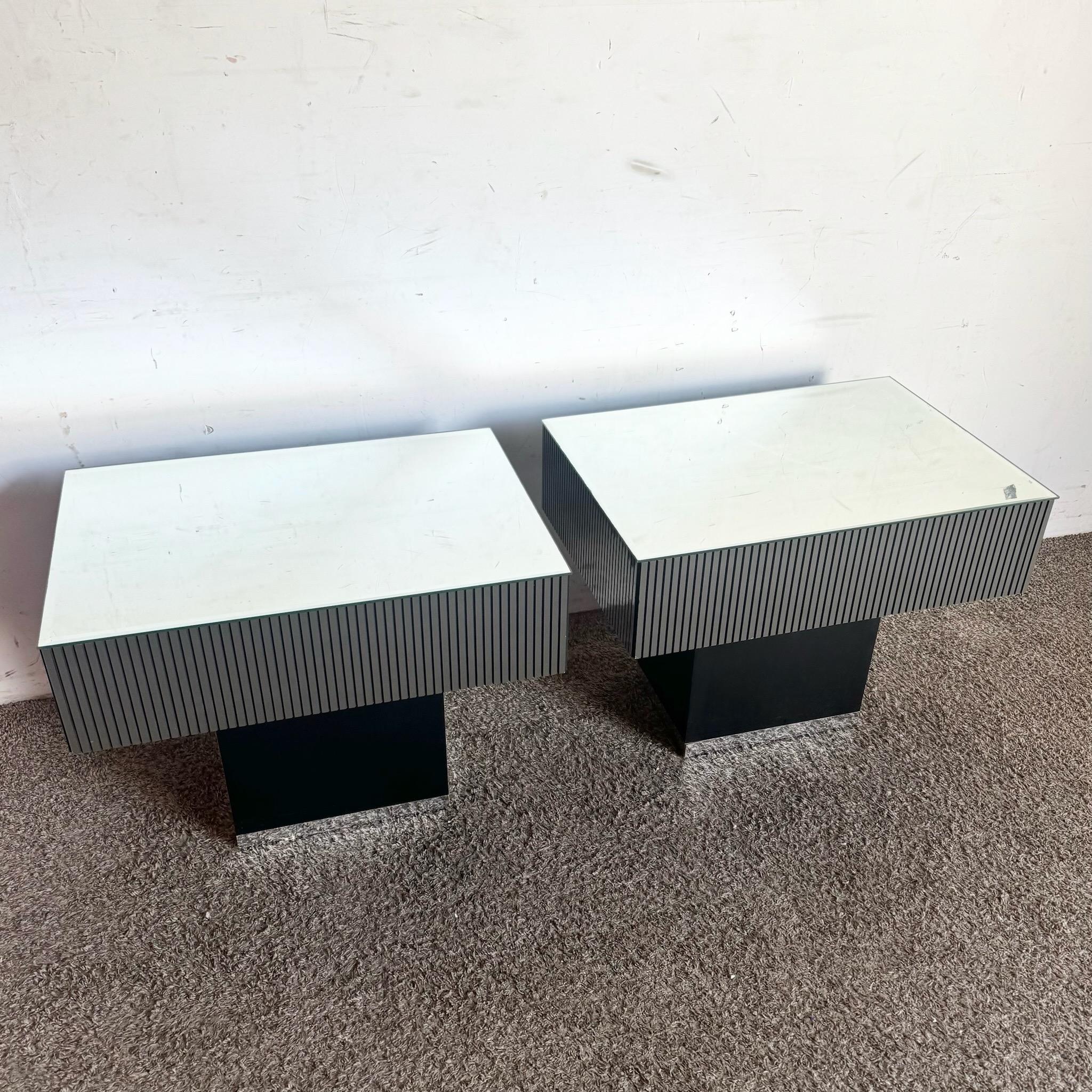 Élevez votre espace avec cette paire de tables d'appoint postmodernes à miroir rayé noir et argent. Ces tables accrocheuses présentent un design rayé audacieux et un plateau en miroir réfléchissant, offrant un mélange parfait de forme et de fonction