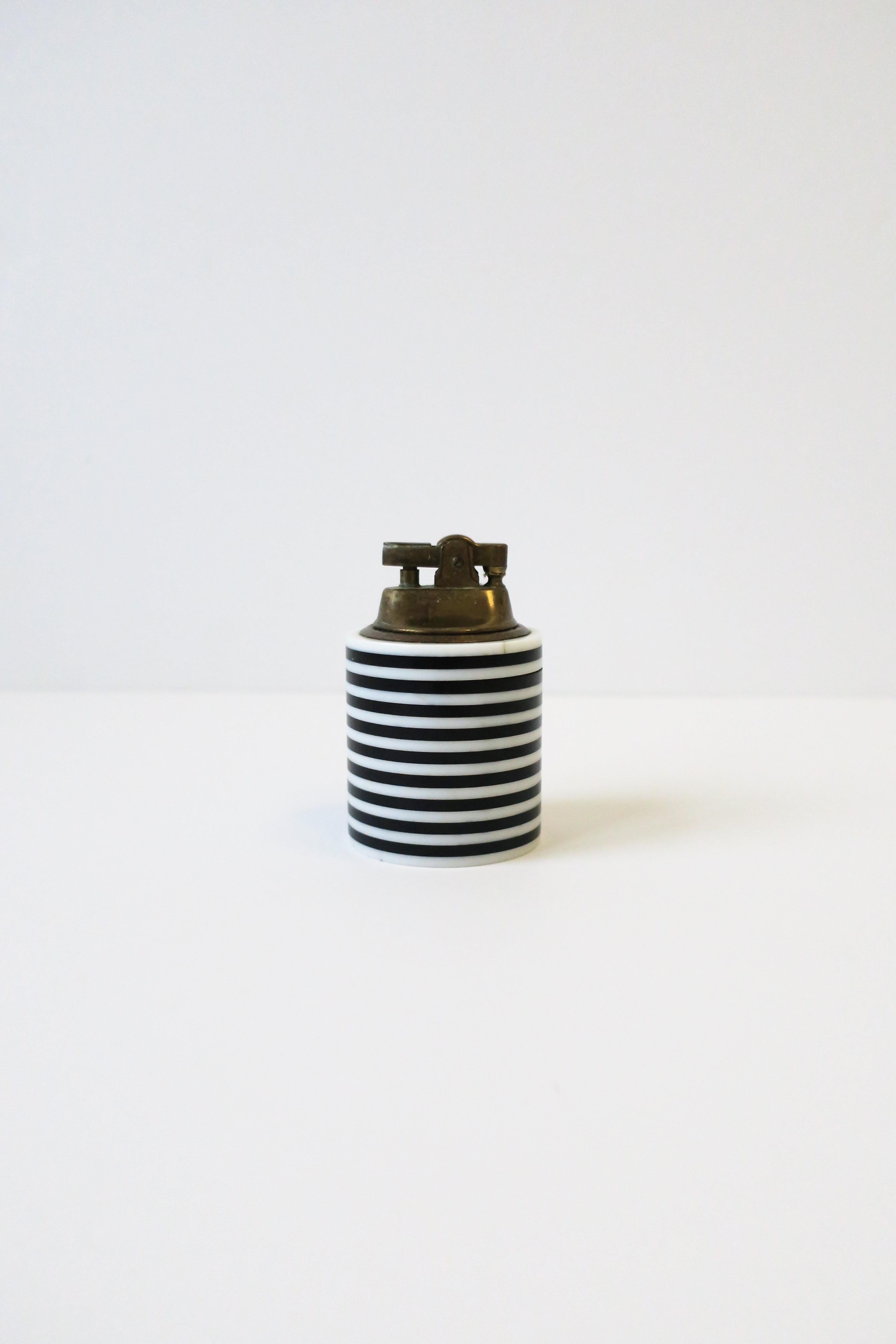 A chic Postmodern black and white striped acrylic/resin and brass lighter for cigarettes, cigar, candles, etc., circa Late 20th century. 

Measures: 2.13