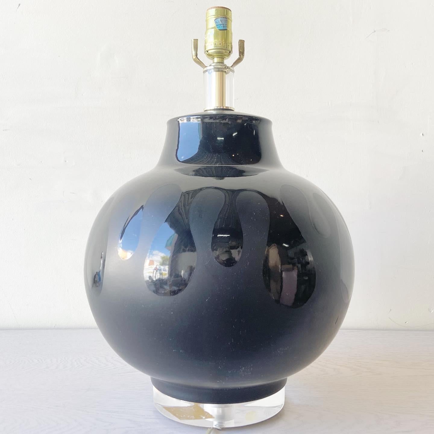 Incroyable lampe de table en céramique. Elle présente un design noir qui associe une finition brillante et une finition mate.
