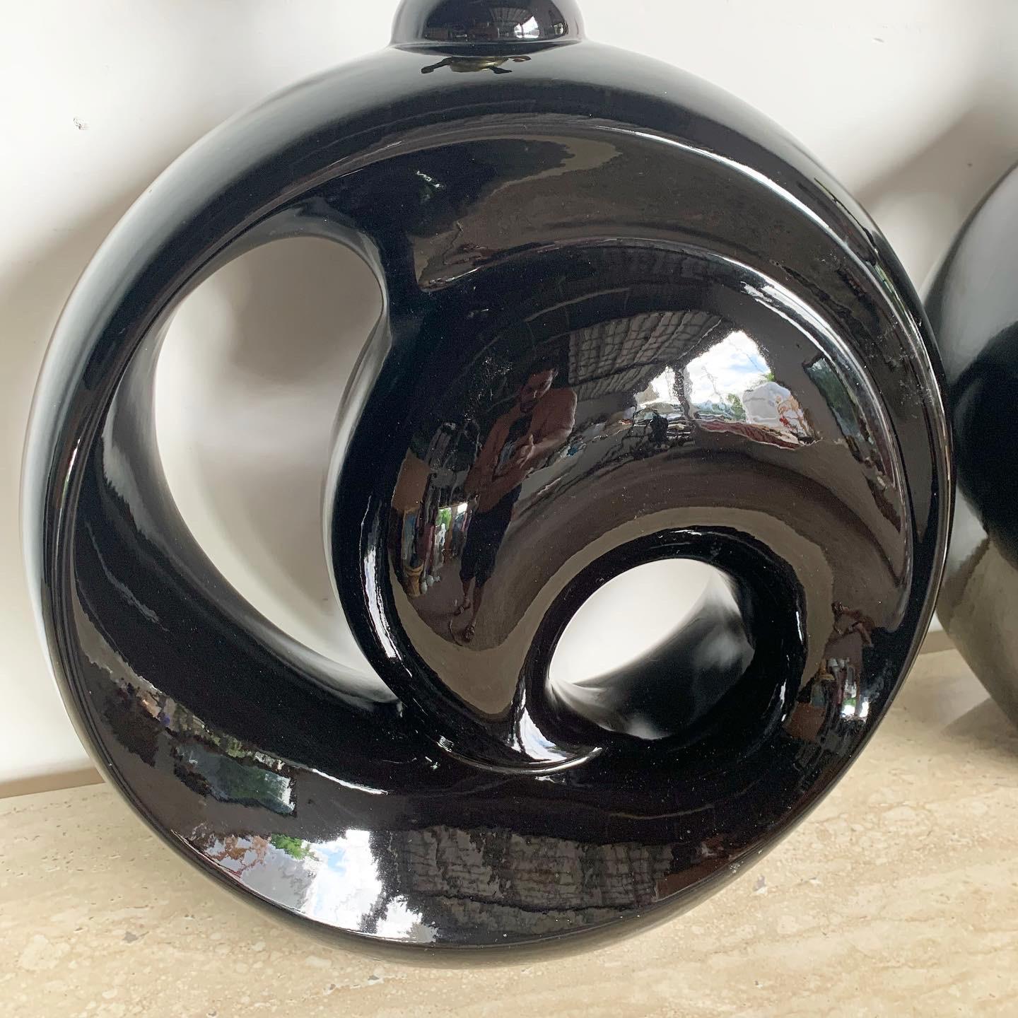 Enhance your space with Postmodern Black Gloss Sculpted Swirl Ceramic Table Lamps, boasting elegant design and sleek aesthetics.

Sculpted swirl design crafted in high-gloss black ceramic.
Exudes a sense of movement and sophistication.
Plays with