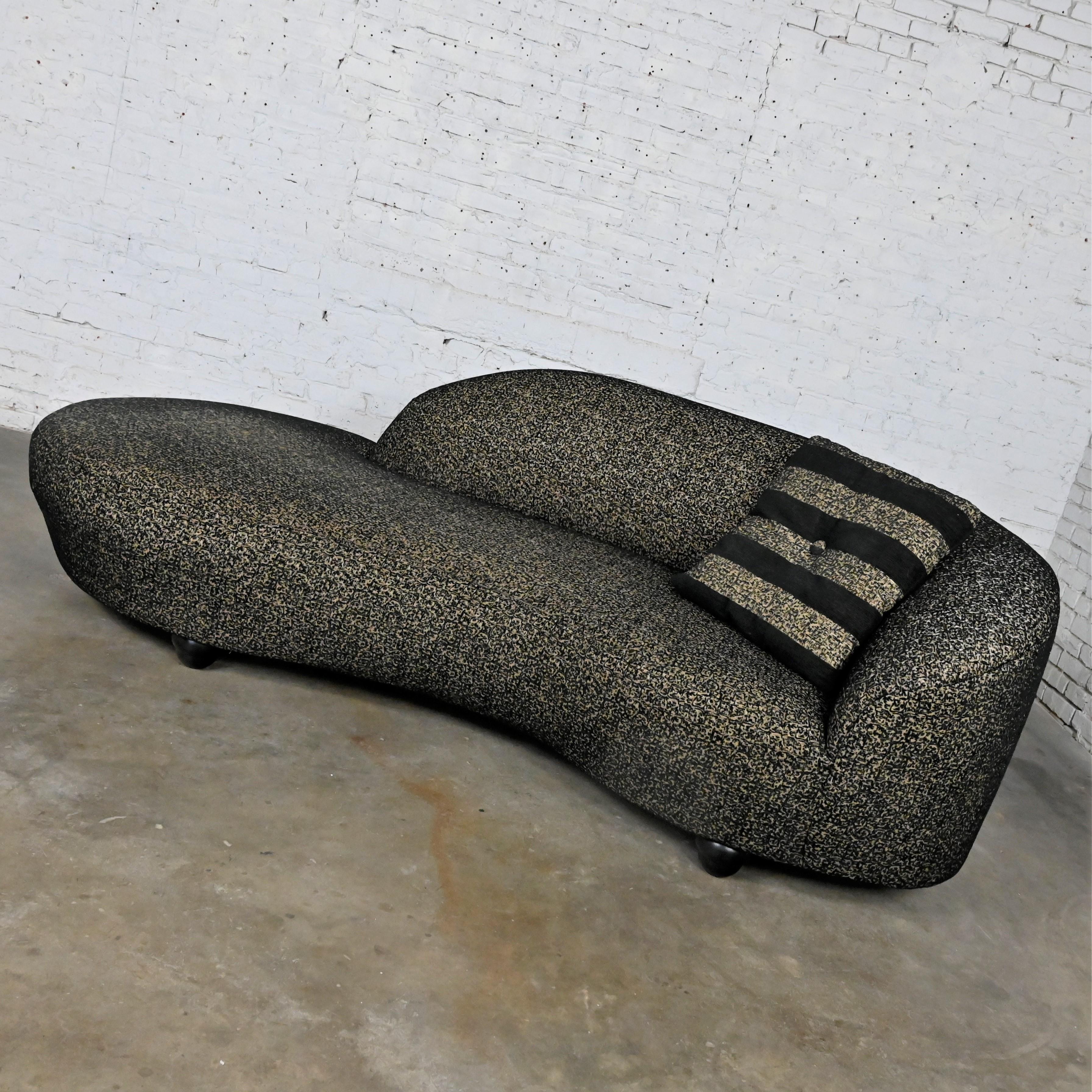 Handsome postmodern black and khaki sort of animal print serpentine cloud-like or biomorphic chaise or sofa with throw pillow on stacked concentric rounded legs. Beautiful condition, keeping in mind that this is vintage and not new so will have