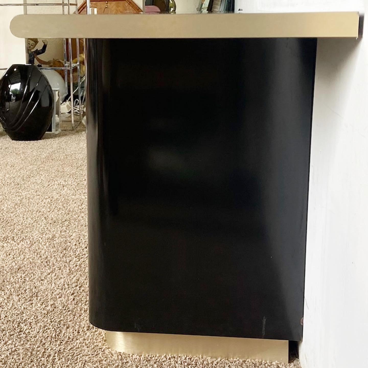 Discover modern elegance with this Black Lacquer Gold T-Shaped Credenza. Featuring a high-gloss black lacquer finish and brushed gold details, it marries style with functionality.
Minor wear and chips around the edges as seen in the photos.