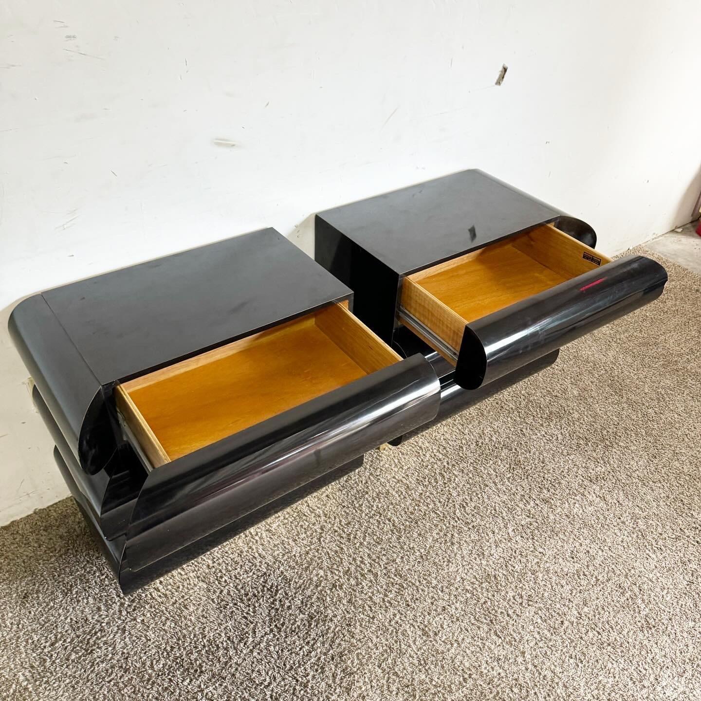 Introduce a modern luxury to your bedroom with these Postmodern Black Lacquer Laminate Bullnose Nightstands on Gold Bases. This pair features a sleek design with smooth bullnose edges and a rich black finish, contrasted by elegant gold bases.