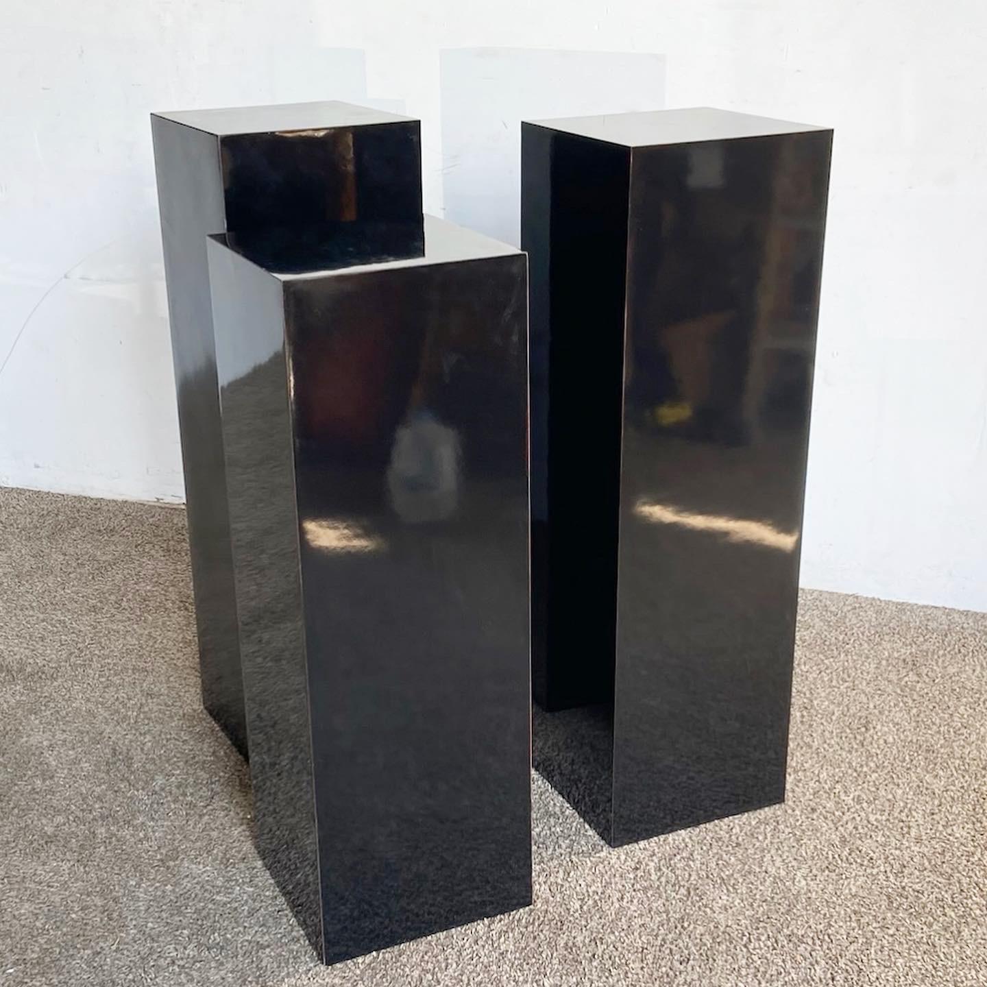 Elevate your contemporary space with this set of three Postmodern Black Lacquer Laminate Pedestals. Laminated in glossy black, they offer a sleek and versatile solution for displaying art or decorative items, capturing the minimalist spirit of