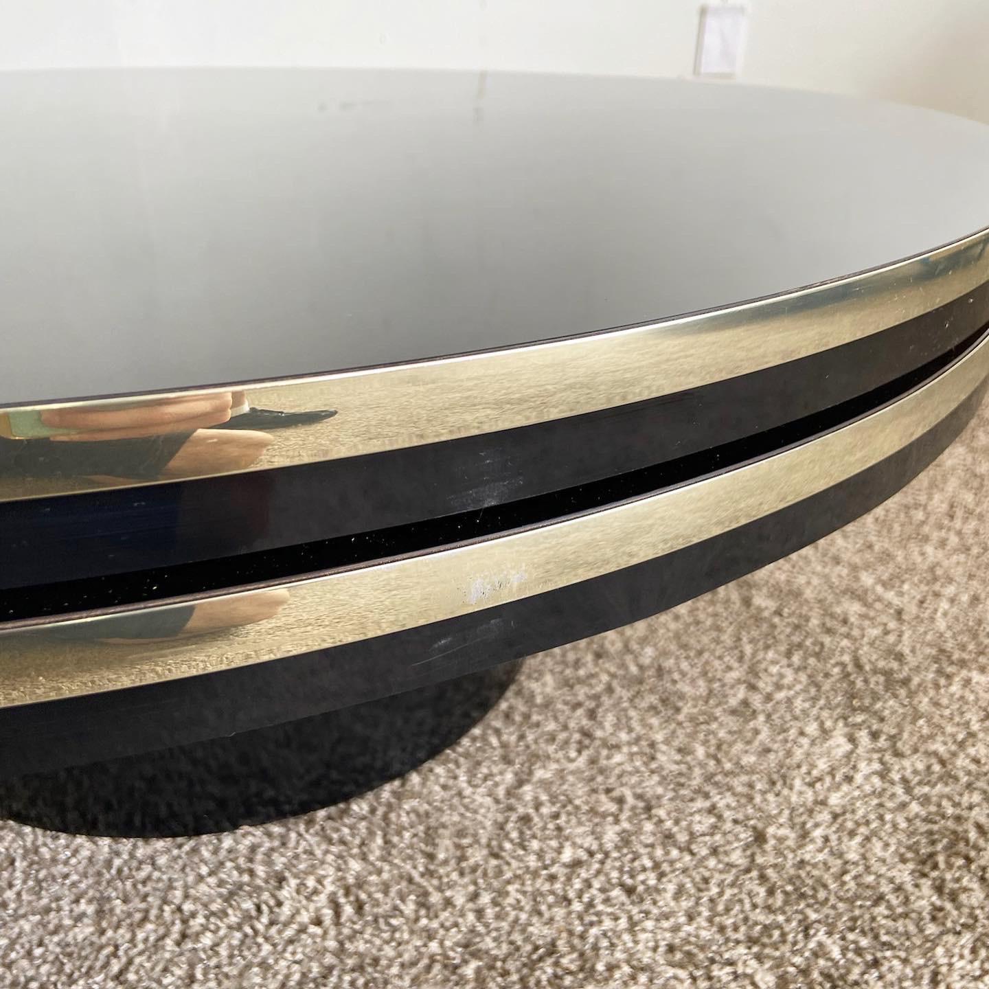 Experience versatility and style with our Postmodern Black Lacquer Laminate Circular Two Tier Swivel Coffee Table with Gold Trim. This unique coffee table features two tiers that swivel 360 degrees, offering flexibility and a dynamic visual appeal.