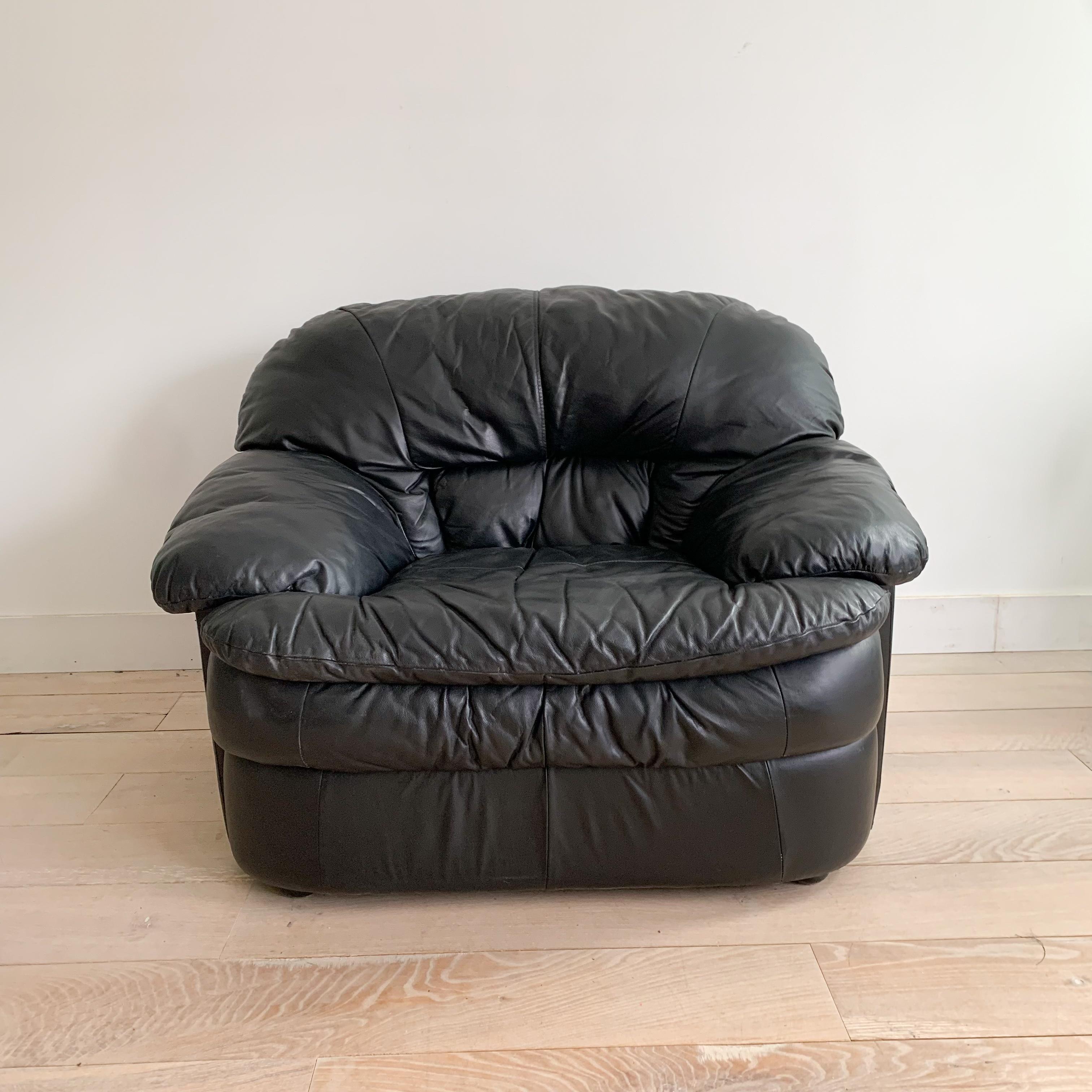 This comfortable postmodern lounge chair features luxurious black leather upholstery. It shows light scuffing and scratching from age and use, adding a touch of vintage charm.

Dimensions: 48” L x 41” W x 35” H (19” seat height)