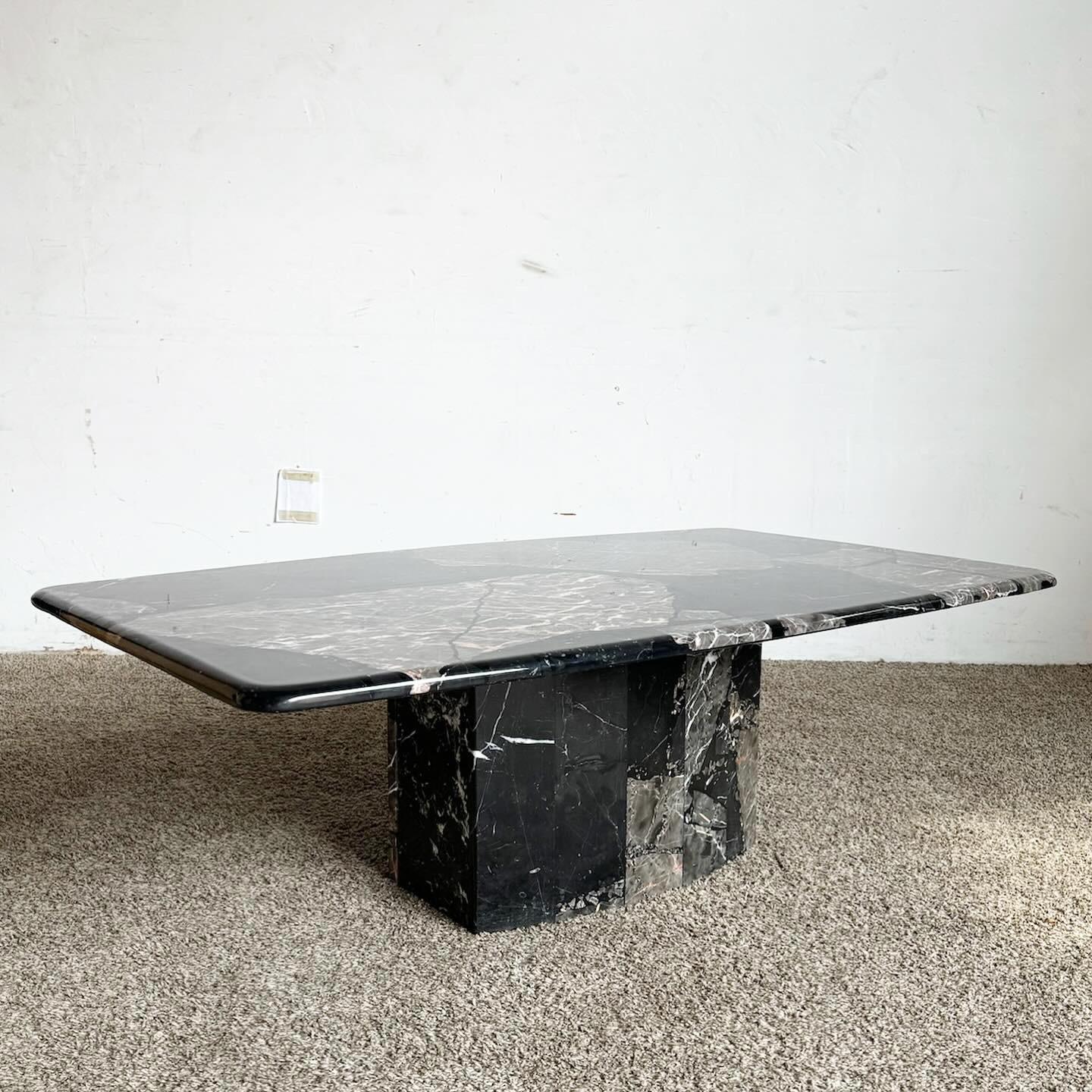 The Postmodern Black Marble Coffee Table on a scalloped pedestal base is a dramatic addition to any living space. With its luxurious black marble top and unique scalloped pedestal, it embodies postmodern elegance. The contrast of sleek marble and