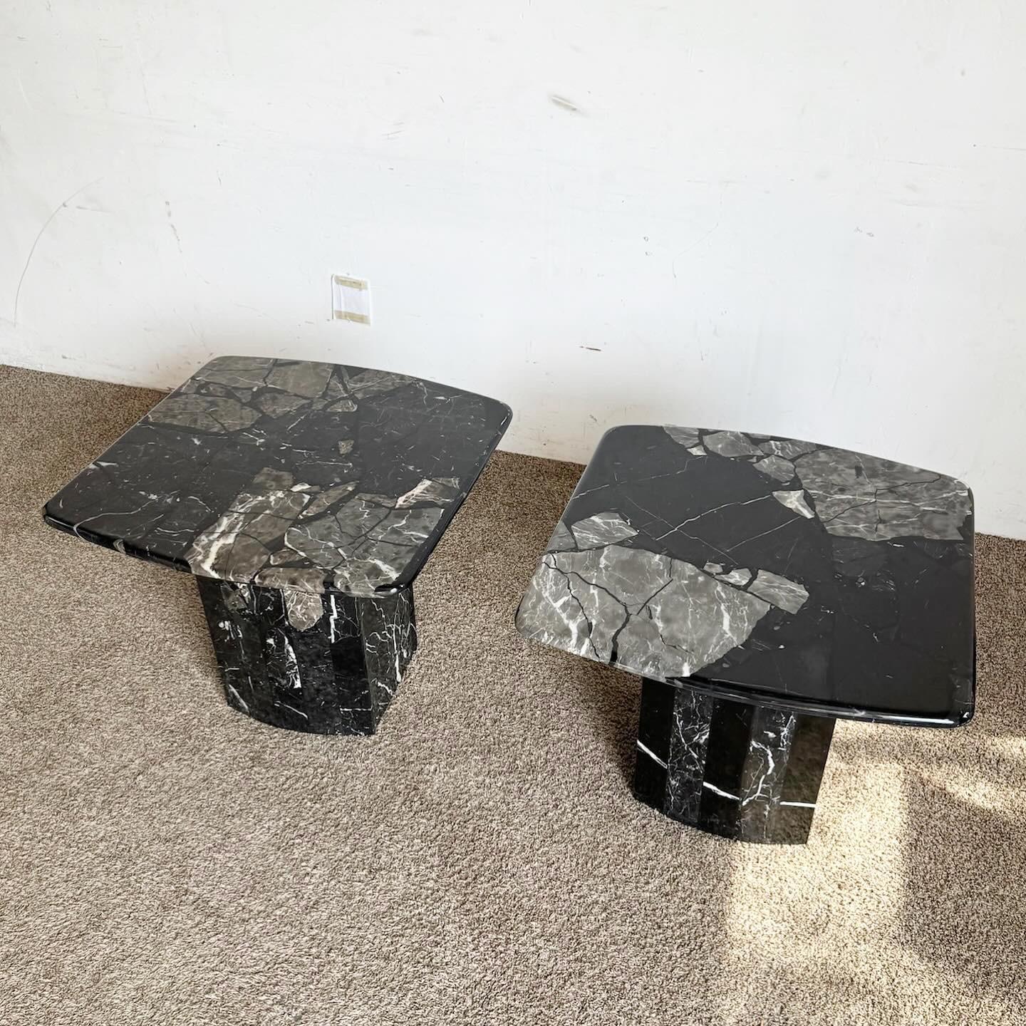 The Postmodern Black Marble Side Tables on scalloped bases, a pair, offer a striking blend of elegance and postmodern design. Each table features a luxurious black marble top with unique veining, supported by an artistic scalloped base. These side