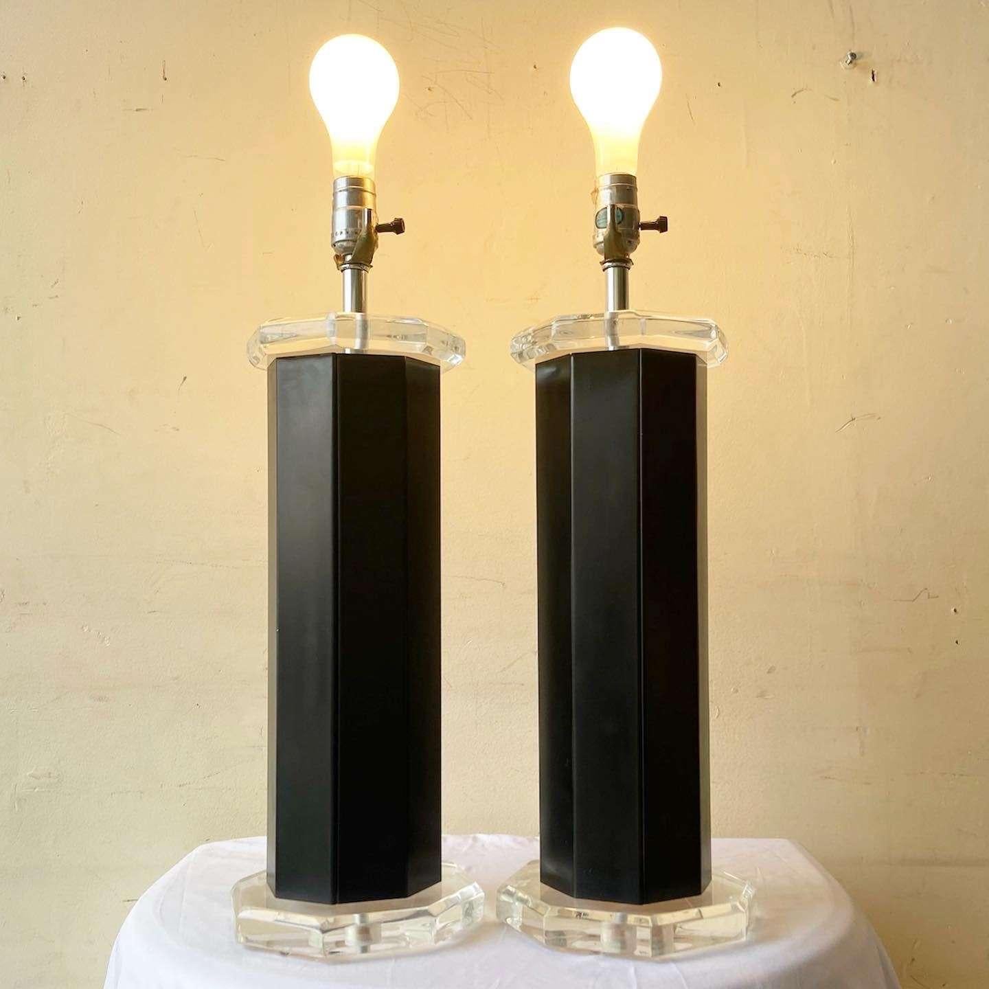 Exceptionnelle paire de lampes de table postmodernes en lucite et métal noir. Chacune présente une forme octogonale avec de la lucite au-dessus et en dessous du corps noir.
