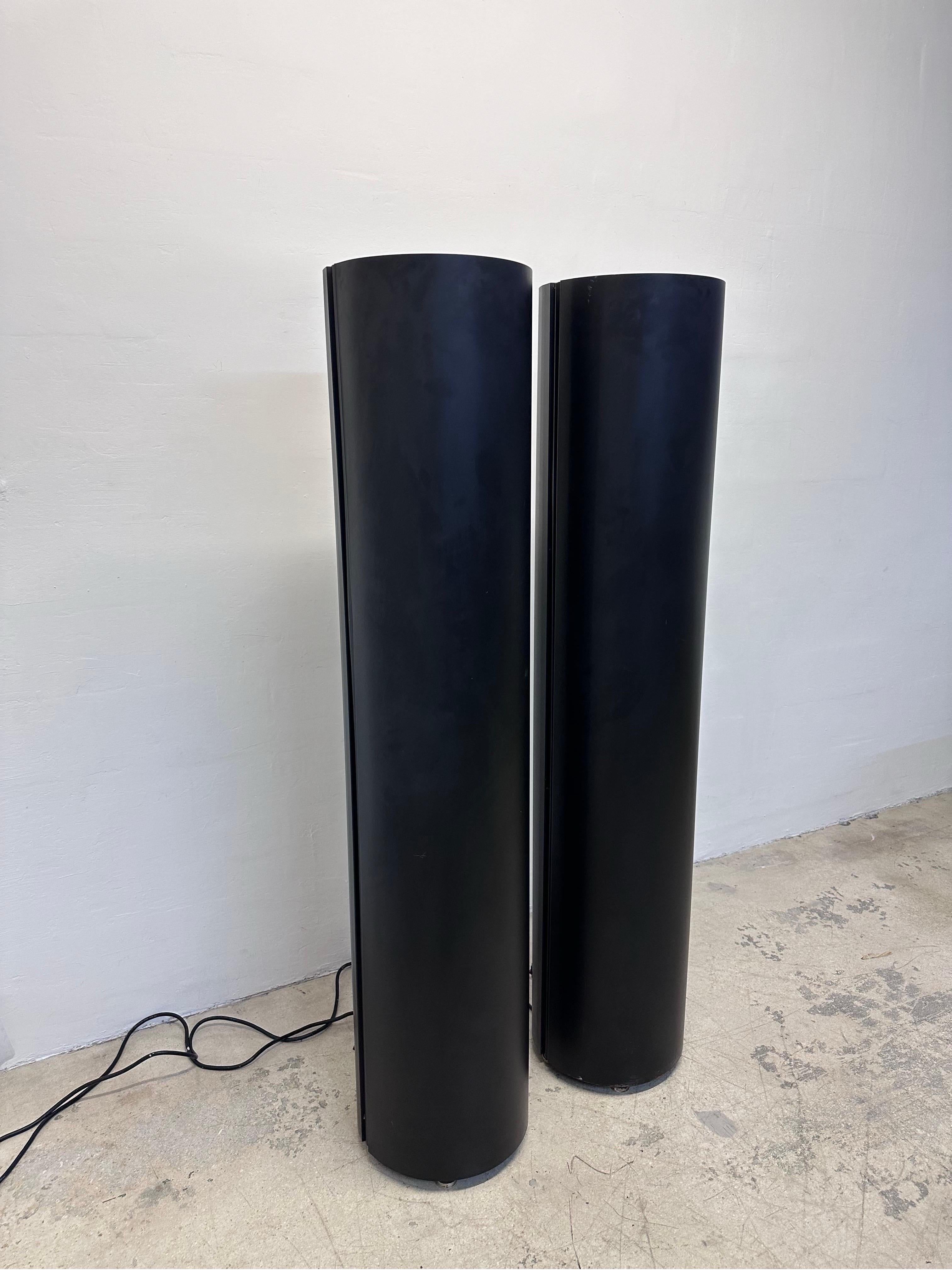 Pair of postmodern industrial black cylindrical torchiere floor lamps, circa 1990s.

Lamps use a specialty 250w metal halide ED28 mercury bulb with E39 base and used specifically for ANSI ballast M58/E.  Bulbs are not included due to risk of