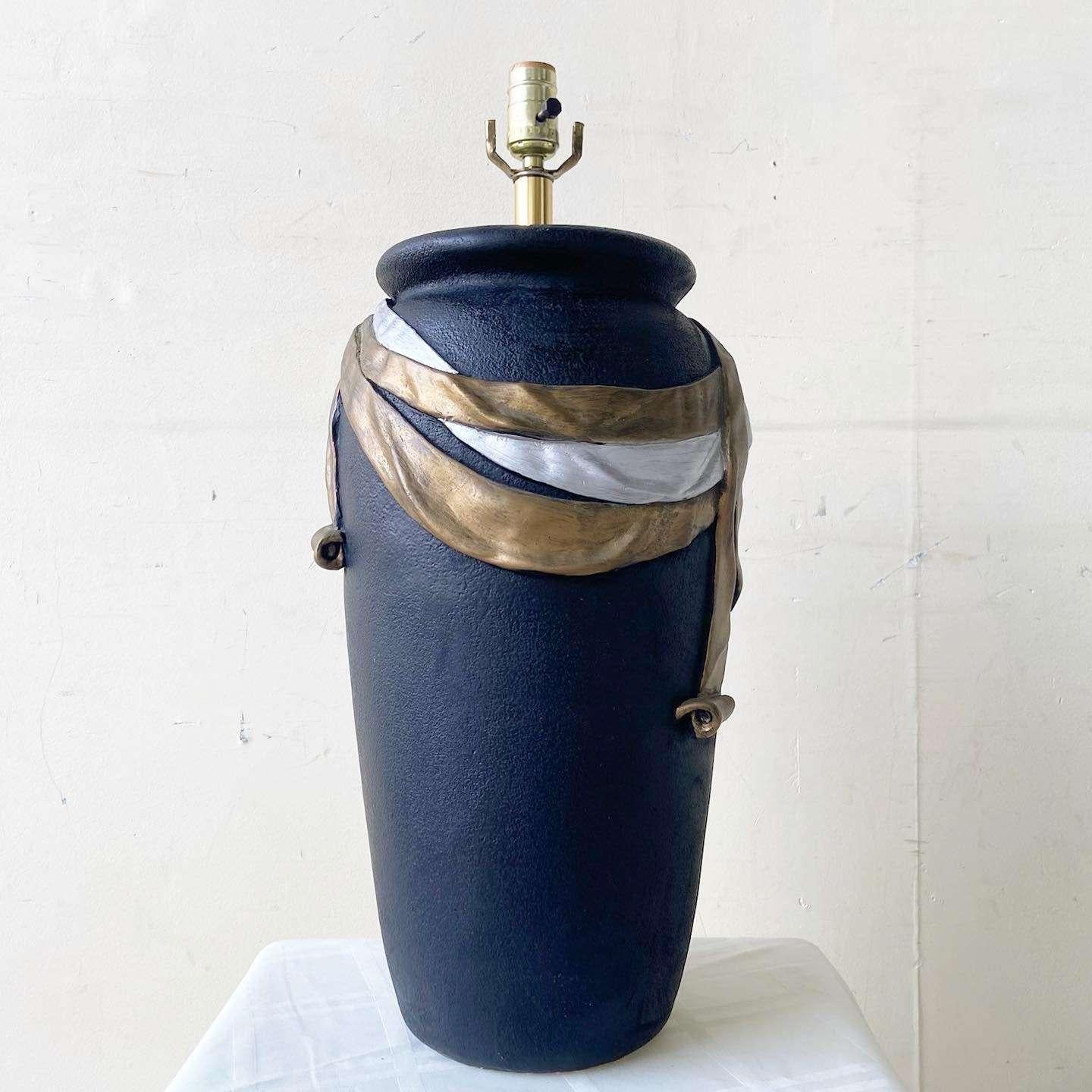 Étonnante lampe de table vintage en céramique postmoderne de Lee Reynolds. Finition noire habillée d'un ruban argenté et doré.
