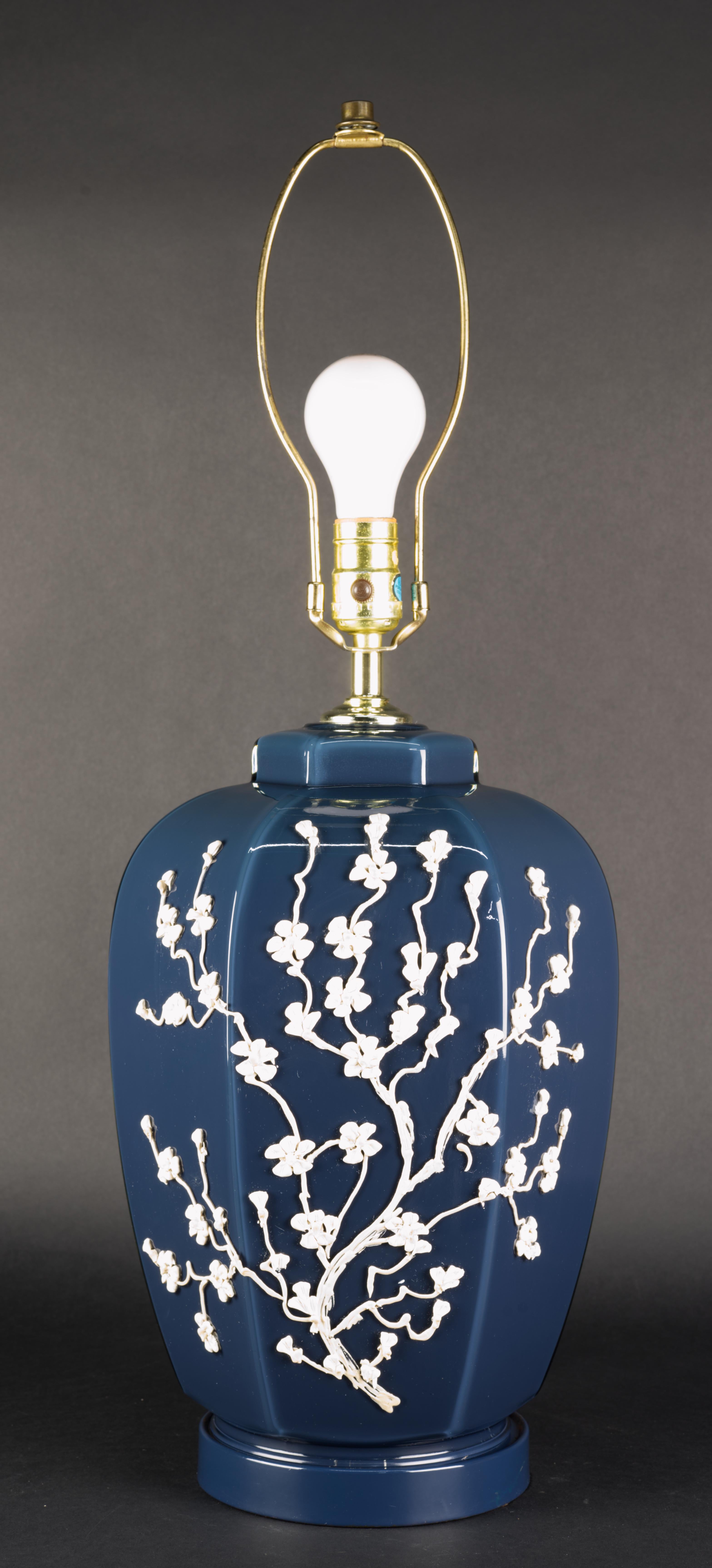  Rare lampe de table postmoderne décorée de branches fleuries blanches sur un corps en verre bleu foncé. La lampe repose sur un socle en métal émaillé assorti à la couleur du verre, créant ainsi une continuité visuelle.
La prise est à trois