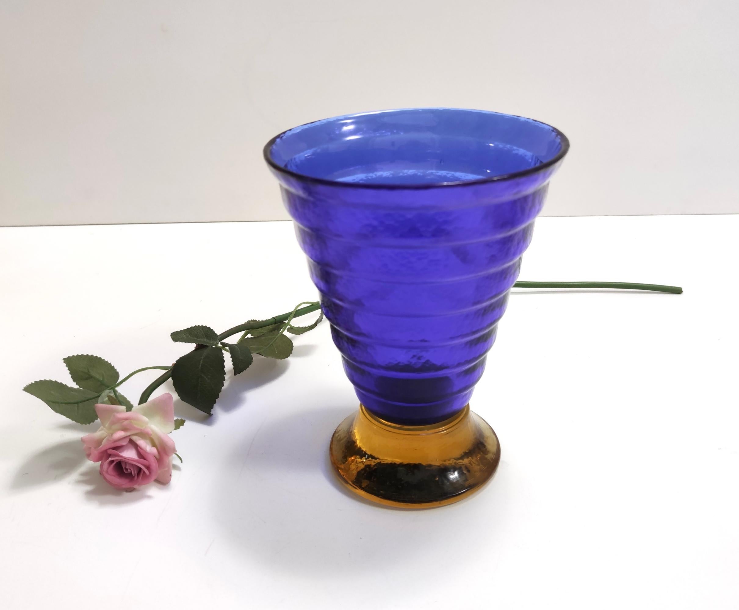 Made in Italy, in Murano, 1970s - 1980s.
This rare and elegant vase is made in blue and yellow Murano glass.
Its style is typical of the 70s - 80s. 
This vase is marked Cá dei Vetrai.
The glass has bubbles and pleasant transparencies due to the