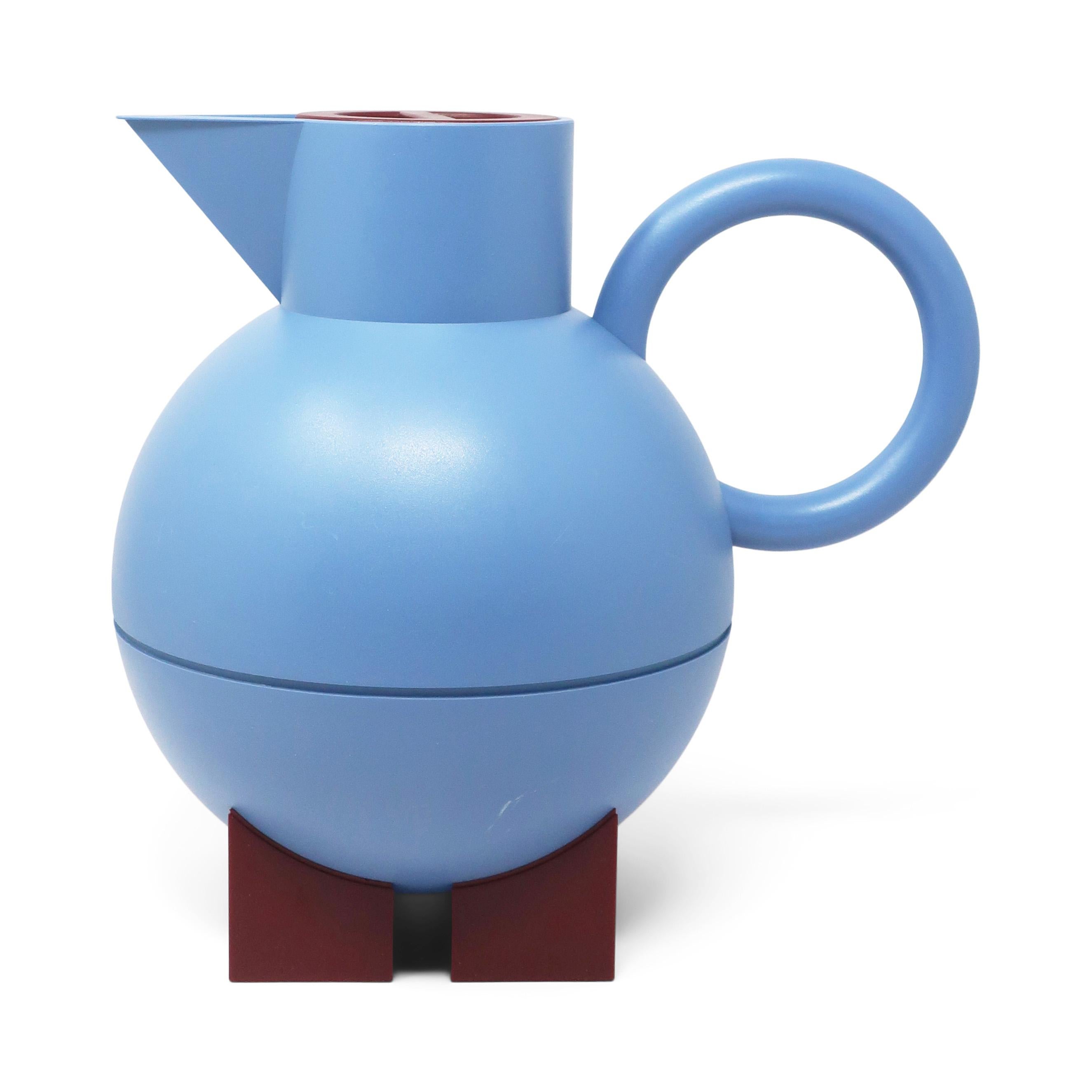 A classic design by Memphis Milano-affiliated American postmodern designer and architect Michael Graves for his Euclid line for Alessi, the Italian home goods powerhouse. A red handle, triangular spout, and rounded body sitting on blue rectangular