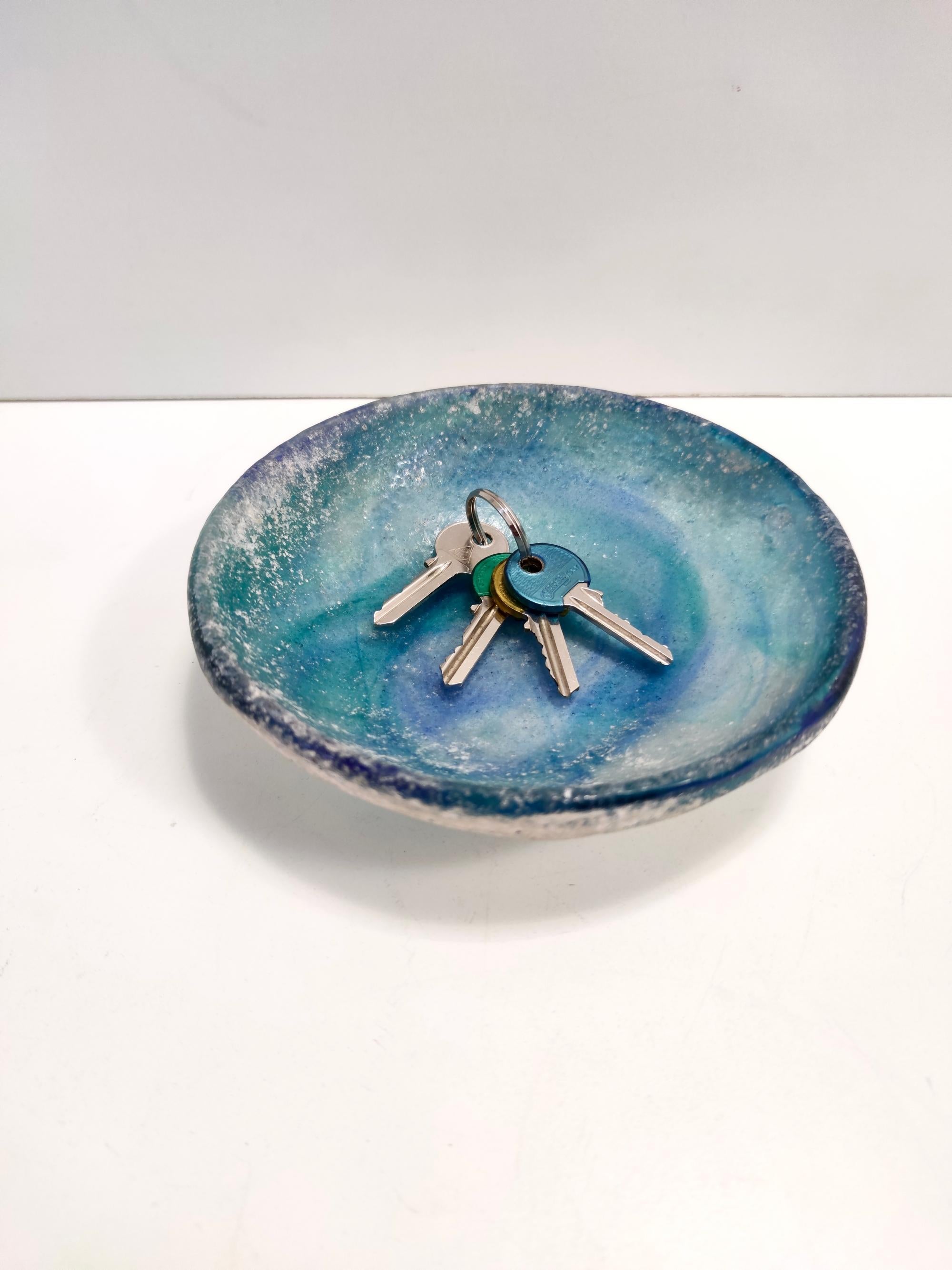 Made in Italy, 1960s - 1970s. 
This bowl / ashtray / vide-poche is made in polychromed blue scavo hand-blown Murano glass.
It is a vintage piece, therefore it might show slight traces of use, but it can be considered as in perfect original condition