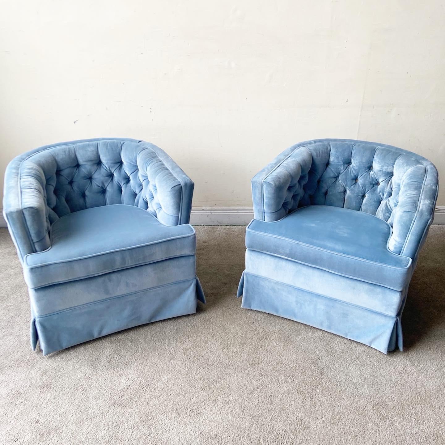 Fantastic set of two blue mid century barrel chairs. Each feature a vibrant blue velvet fabric with a tufted back rest and all around the outside of the chairs.