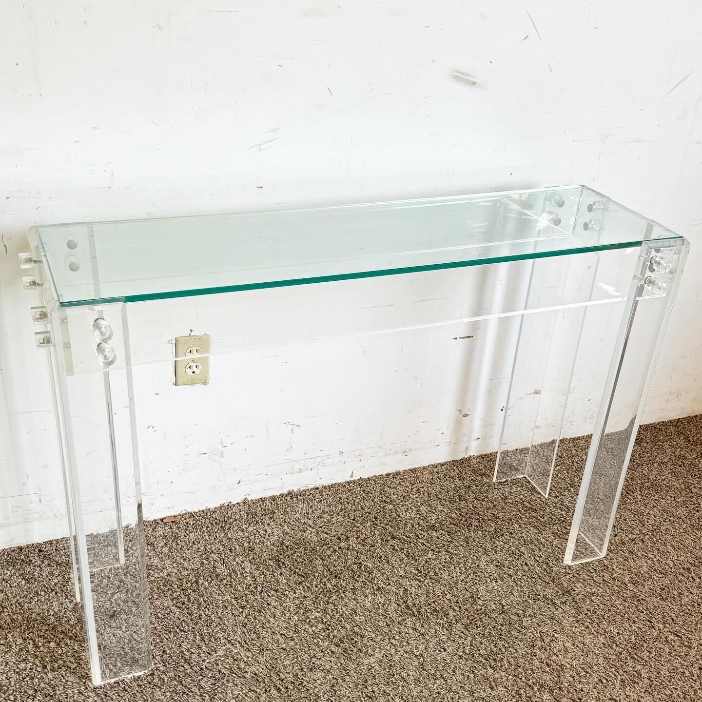 Dive into the innovation of postmodern design with this Bolted Lucite and Inlaid Glass Top Console Table. Showcasing a transparent Lucite frame with industrial-style bolts, this piece merges minimalist aesthetics with a contemporary edge. The inlaid