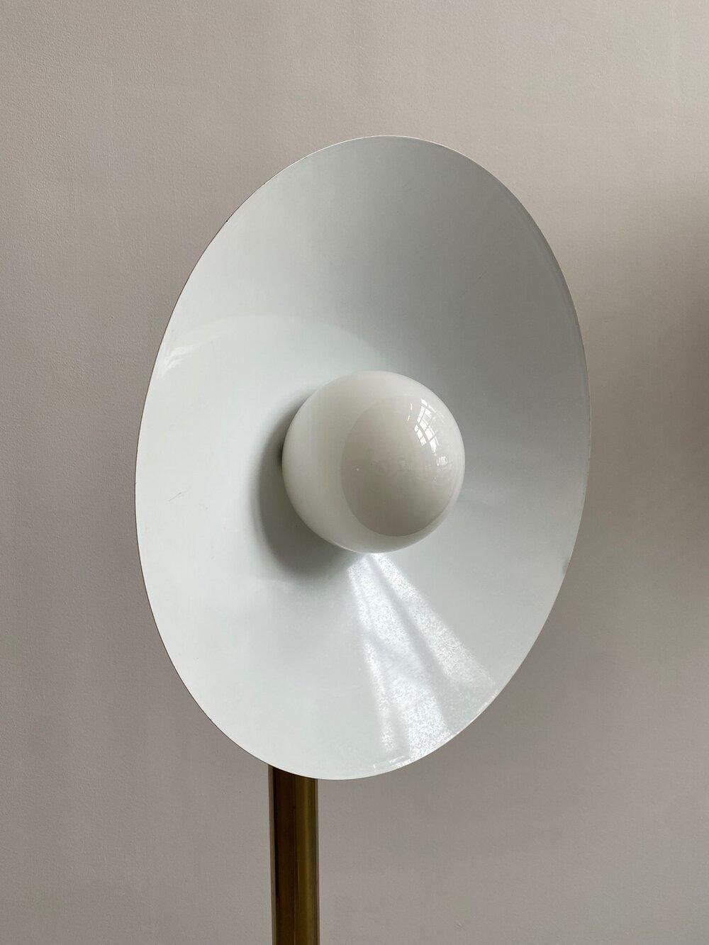 A stunning postmodern brass globe floor lamp that has the power to take over a room. The finishing is fine brass quality with a shade that boast a greenish hue. The bass weight is Koch and Lowy but we believe someone custom made this design using