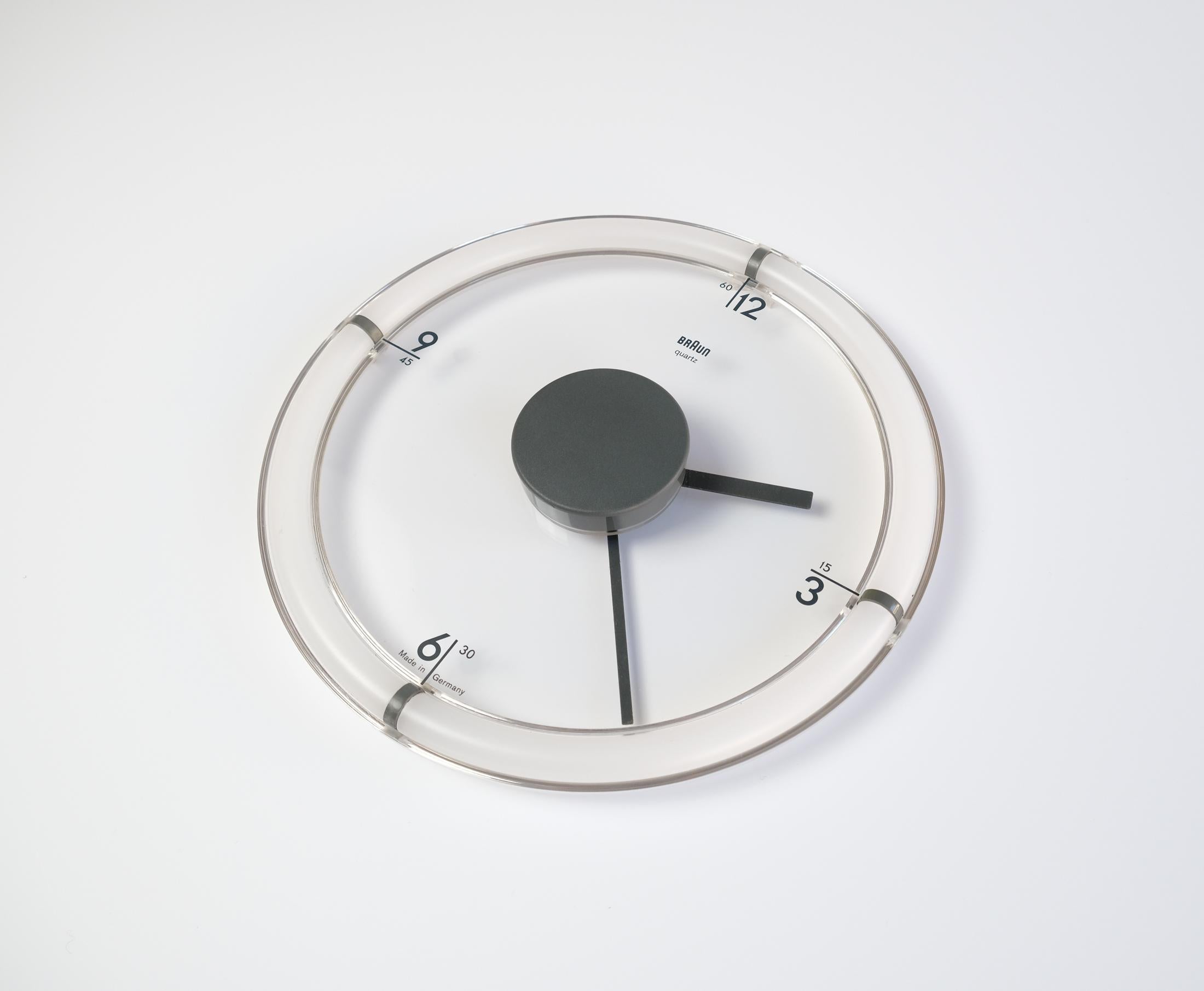 A rare and iconic Model ABW-35 BRAUN wall clock designed by Dietrich Lubs in 1988. 

With the ABW 35, Lubs devised a way for the clock to blend into whatever background it's placed over by making the face transparent. Equally, the numbers and hands