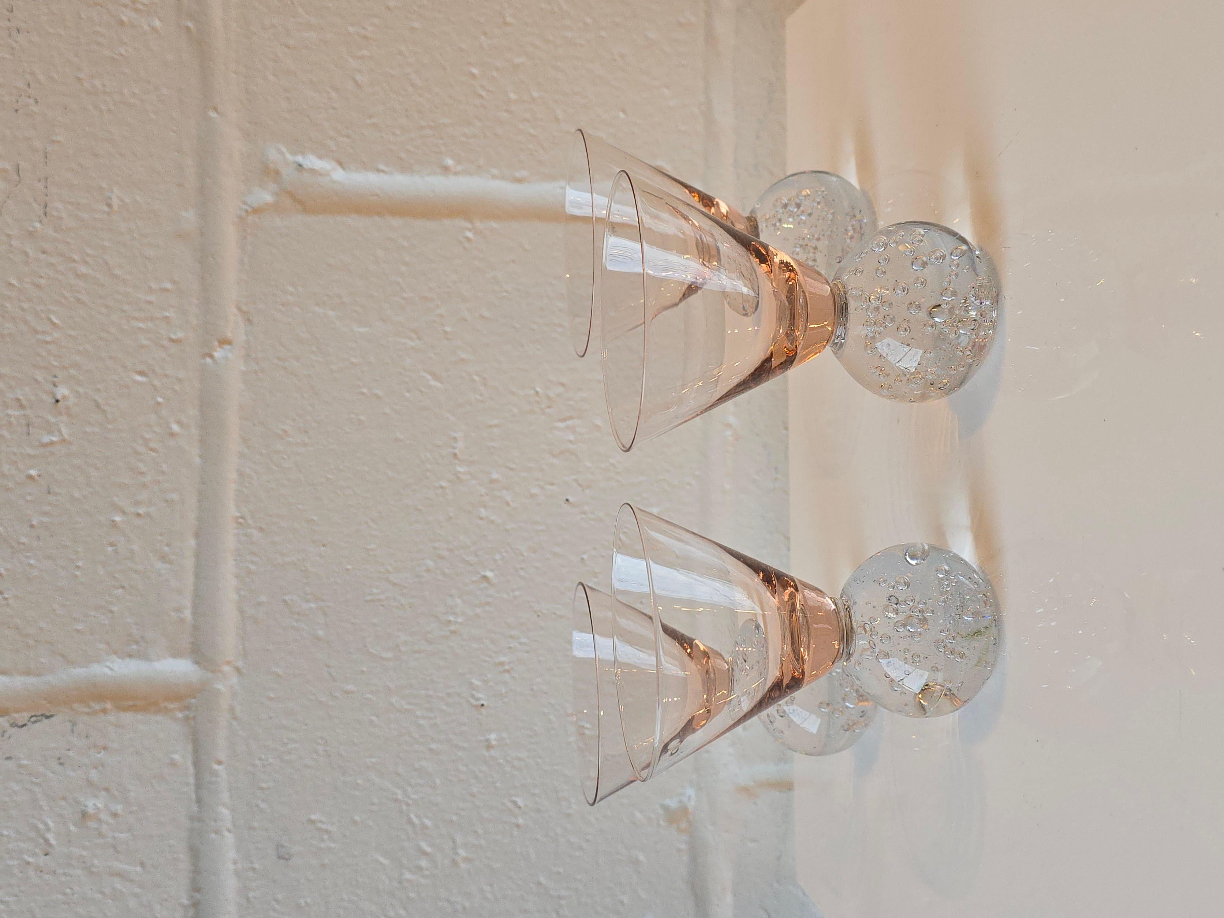 Super cool postmodern cocktail small glasses. This Memphis style glasses feature a rounded cylindrical base with a wide open triangular top in the similar shape as martini glass tops. The cylindrical base is a soft/champagne pink glass colour and