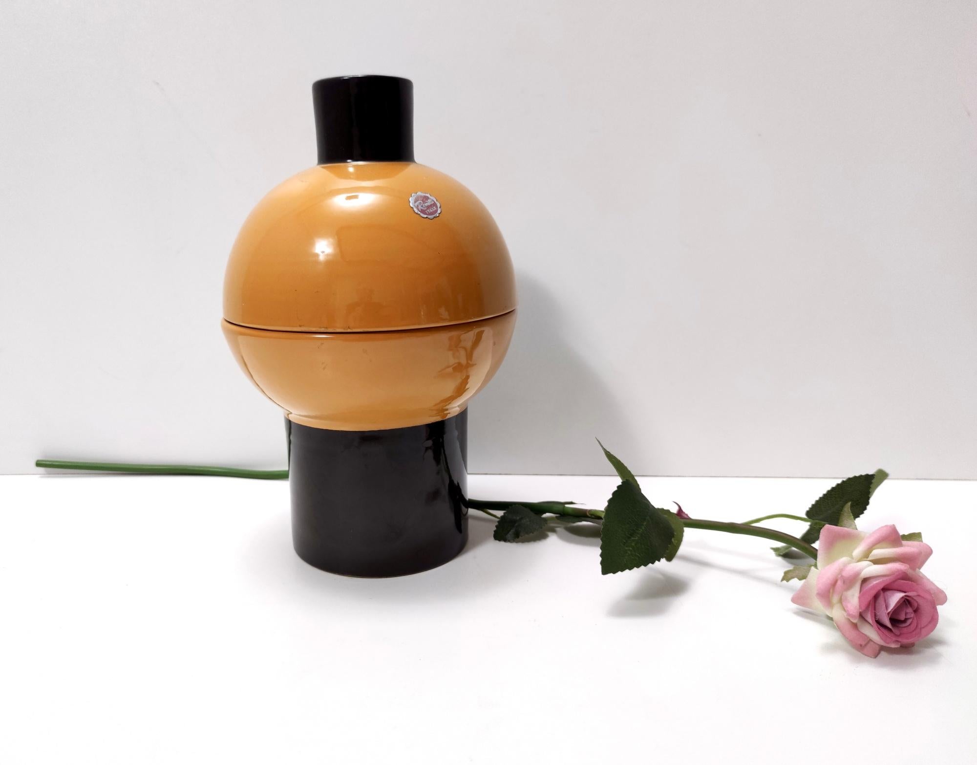 Made in Italy, 1960s-1970s.
This cookie jar is labelled and signed by Rometti Italy.
This item features a central spheric part that is divided on its median, which separates the base and the lid. This part has a cylindrical pommel and lays on a