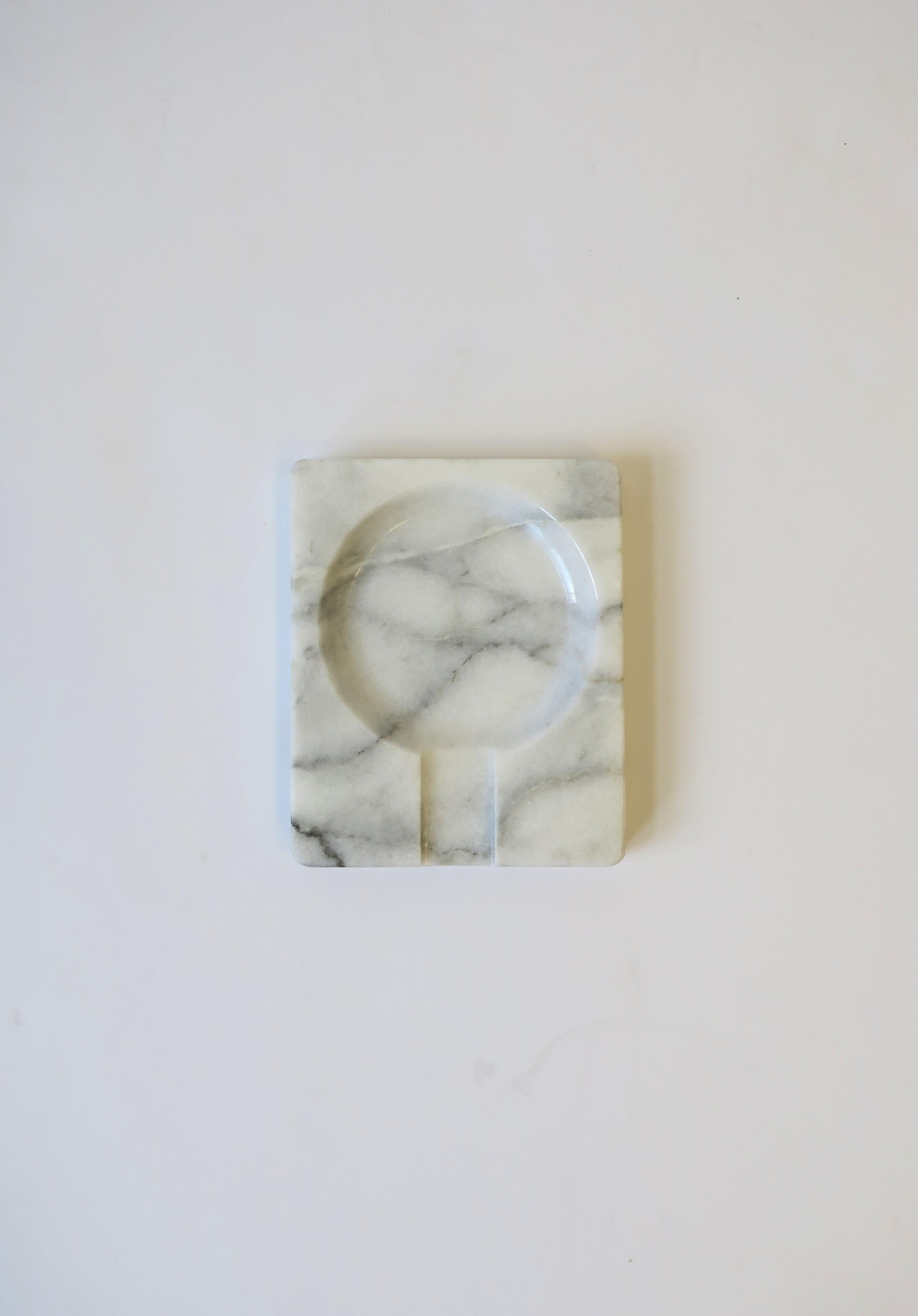 A Post-Modern Carrara marble ashtray or vide-poche catchall, circa 1970s. Piece is rectangular with cutout area for tobacco products (cigar, cigarette, etc.) Alternatively, piece may be used as a catchall for jewelry (as demonstrated) or other small