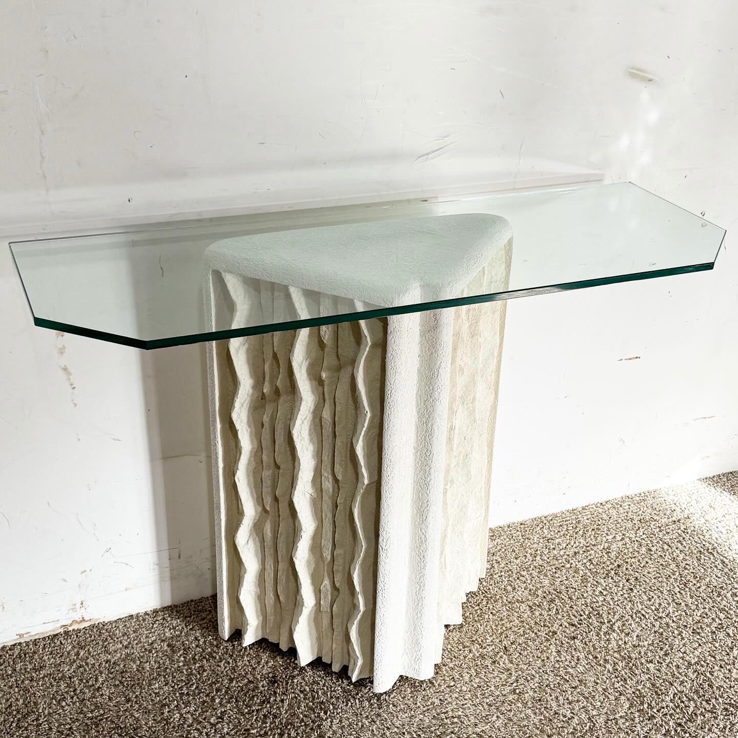 Erleben Sie die Unverwechselbarkeit der Postmoderne mit dem Cast Plaster Glass Top Console Table. Dieser Tisch verfügt über einen einzigartig gestalteten Gipssockel mit den Maßen 20,5 B, 10 T und 29 H, der eine glatte Glasplatte trägt. Die