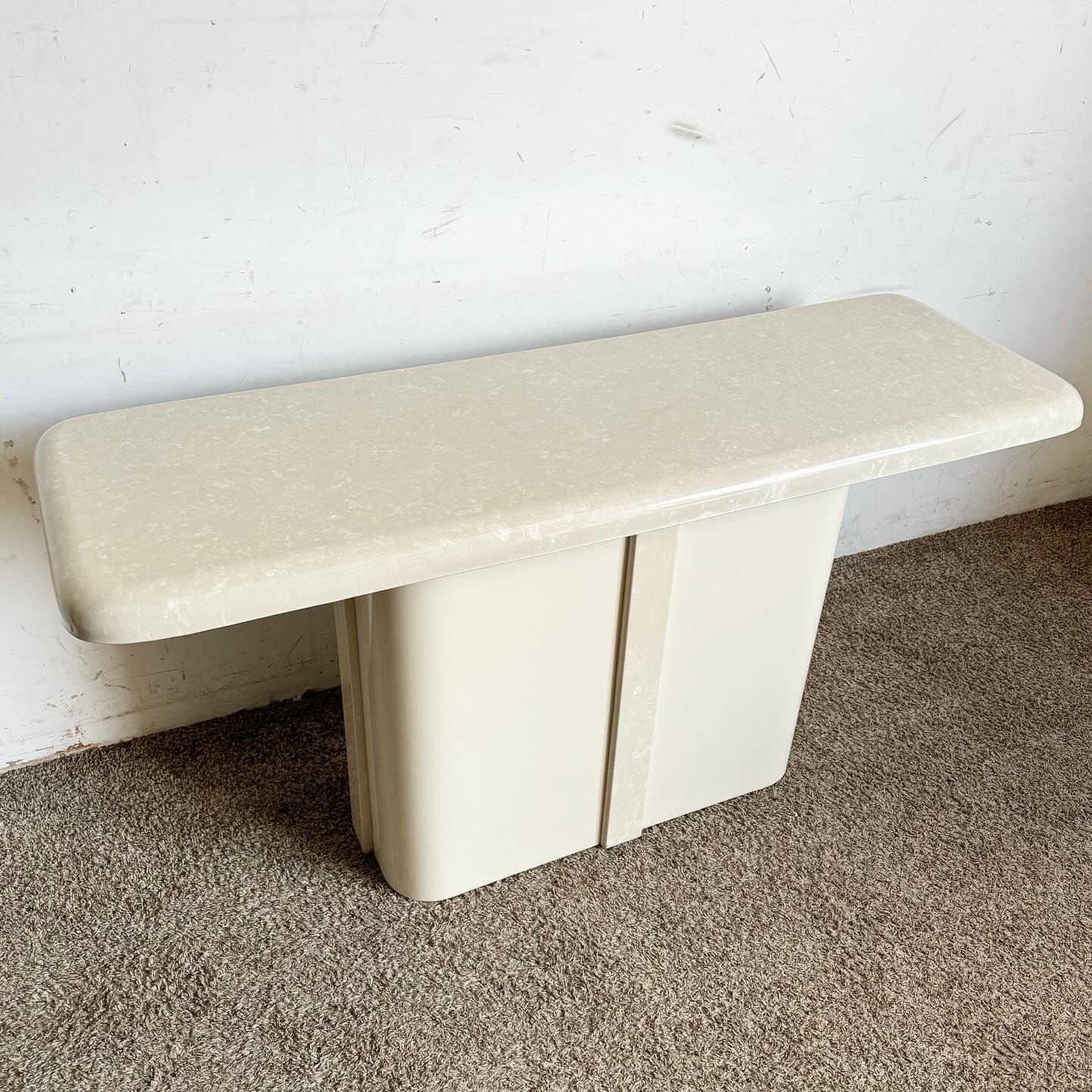 Embrace the luxurious and innovative design of this Postmodern Cast Cream Faux Marble Console Table. Featuring a cream faux marble finish that mimics the elegance of real marble, this table stands out with its bold geometric shapes and sophisticated