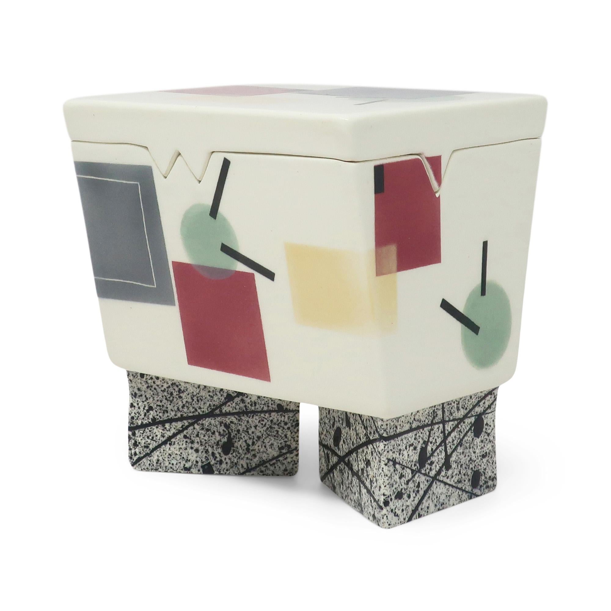 Precioso joyero o baratija de cerámica postmoderna hecho a mano por Rita Duvall, de estilo similar a la obra de Peter Shire y Michael Duvall.  Esmaltada en blanco y de forma rectangular con tapa perfectamente angular pintada con formas aerografiadas
